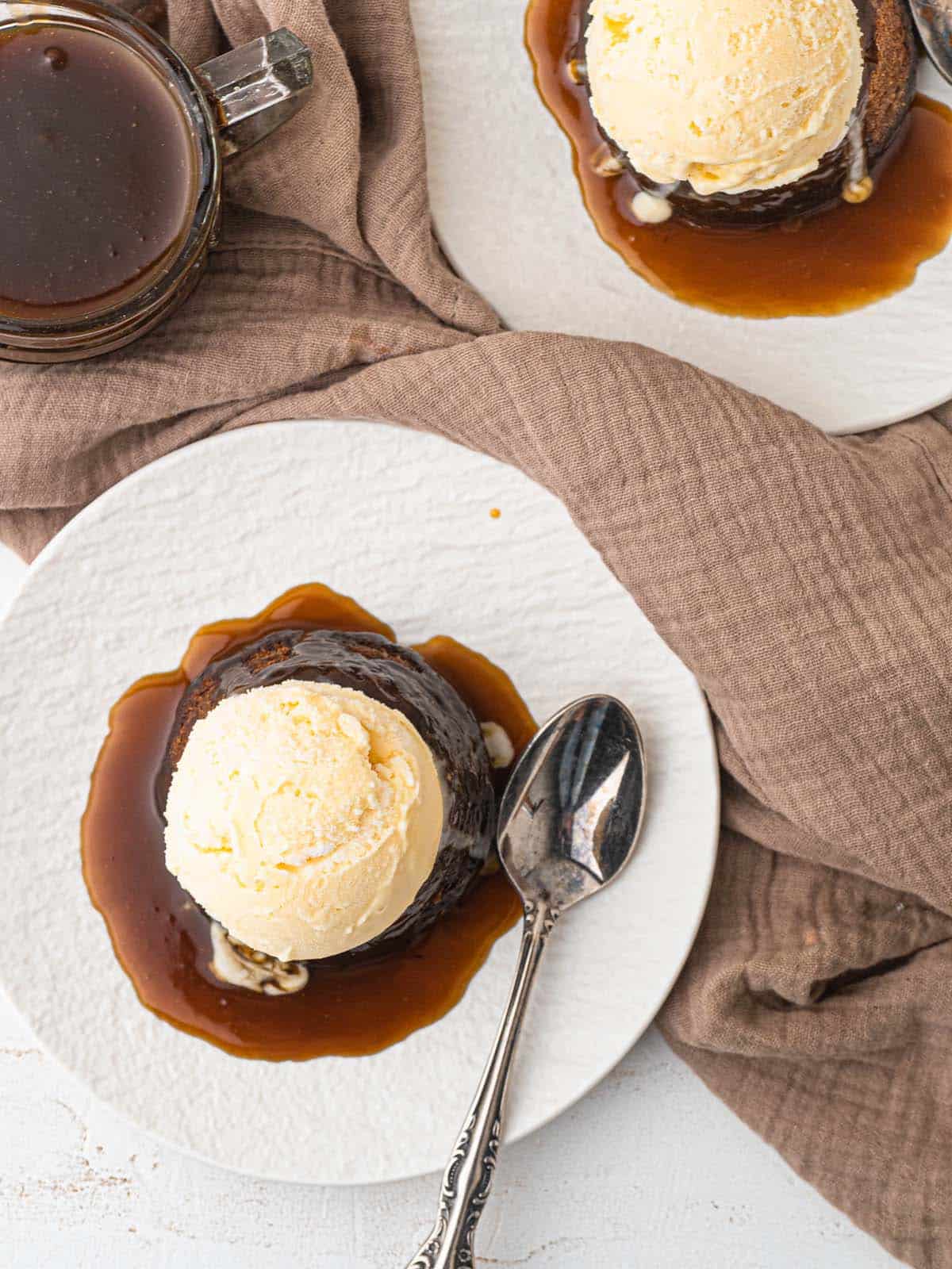 Sticky toffee pudding topped with butterscotch sauce and ice cream