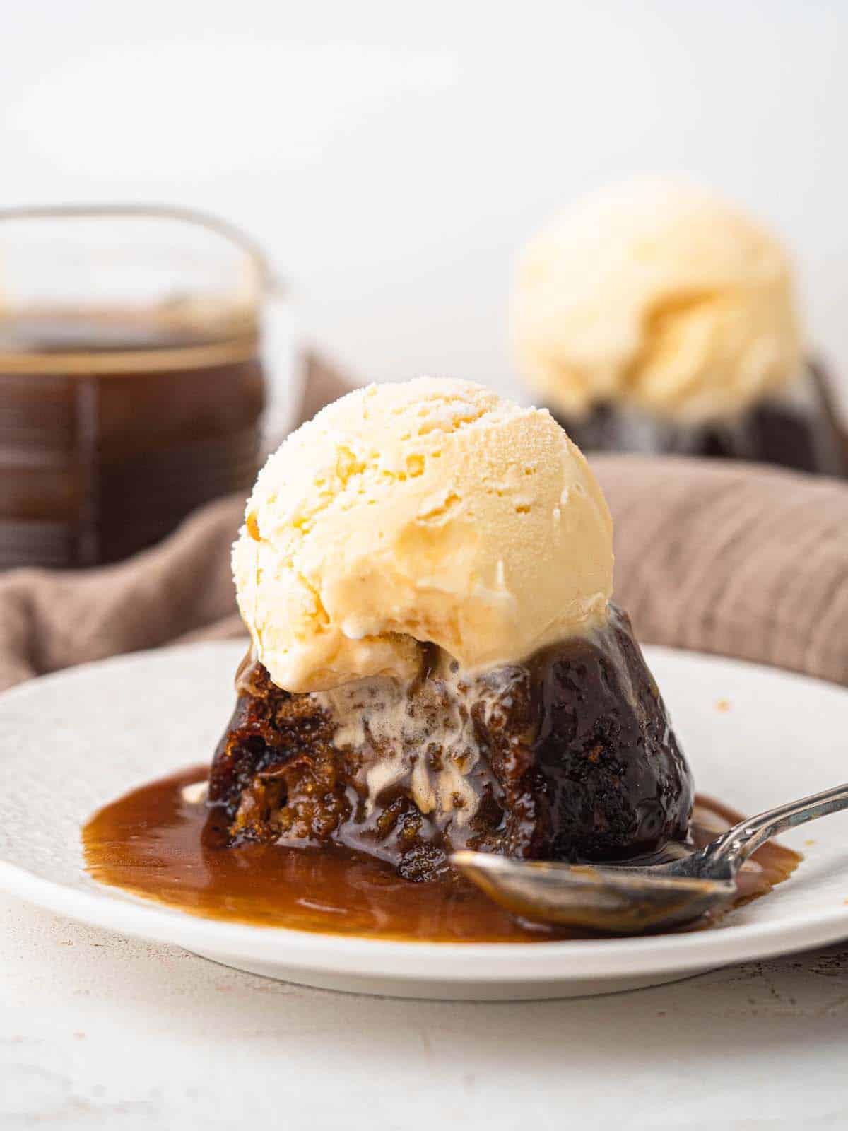 Sticky toffee pudding topped with butterscotch sauce and ice cream