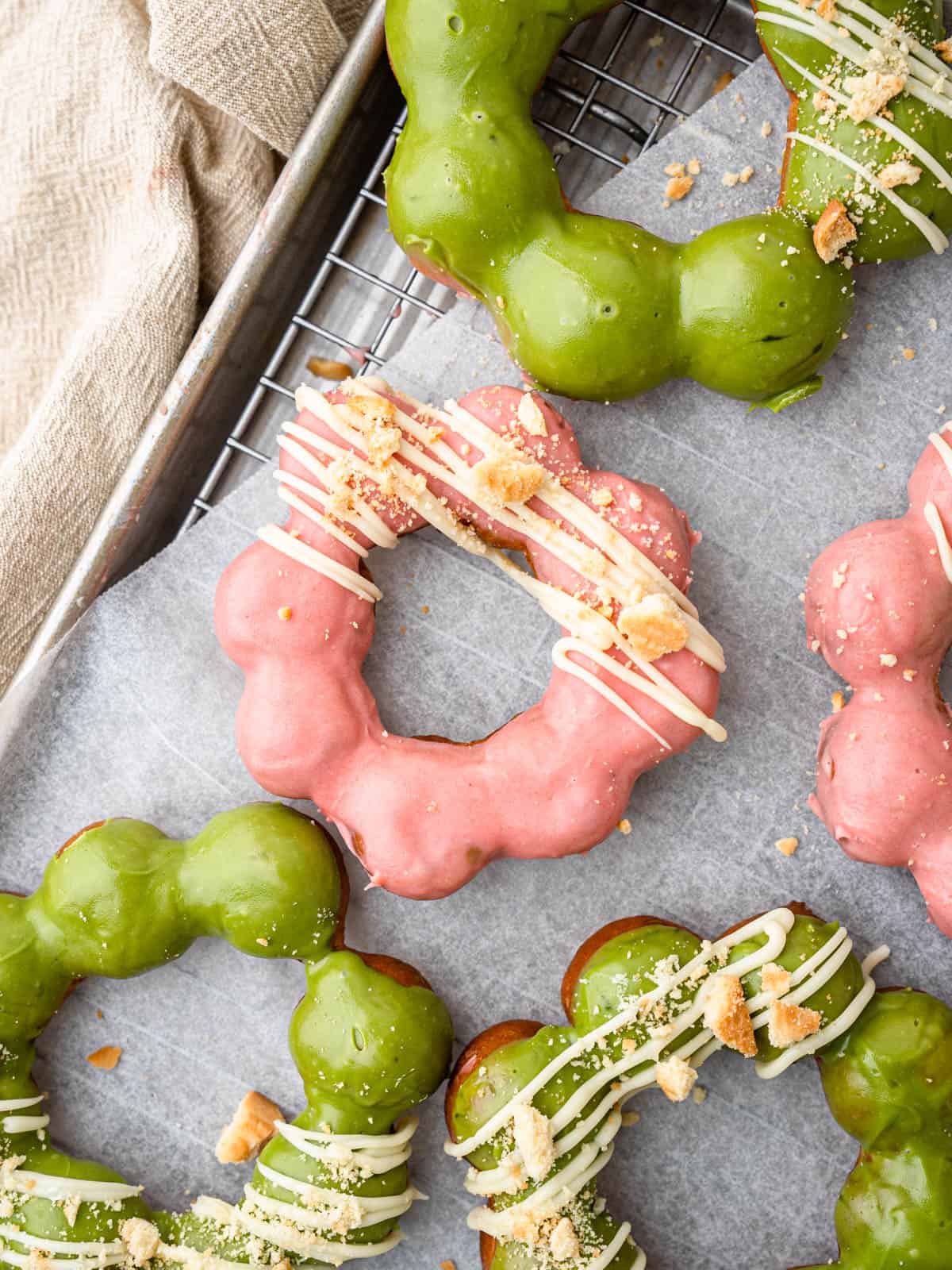 fried mochi donuts frosted with matcha and strawberry white chocolate frosting