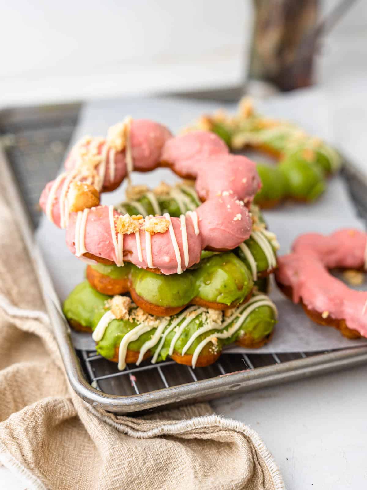 fried mochi donuts frosted with matcha and strawberry white chocolate frosting