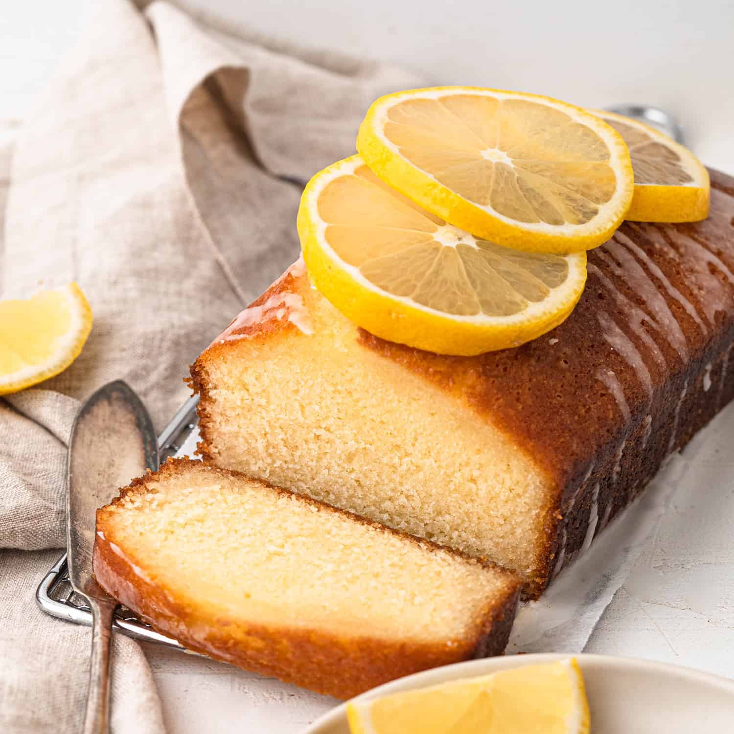 lemon loaf cake topped with a drizzle of icing and topped with slices of lemon