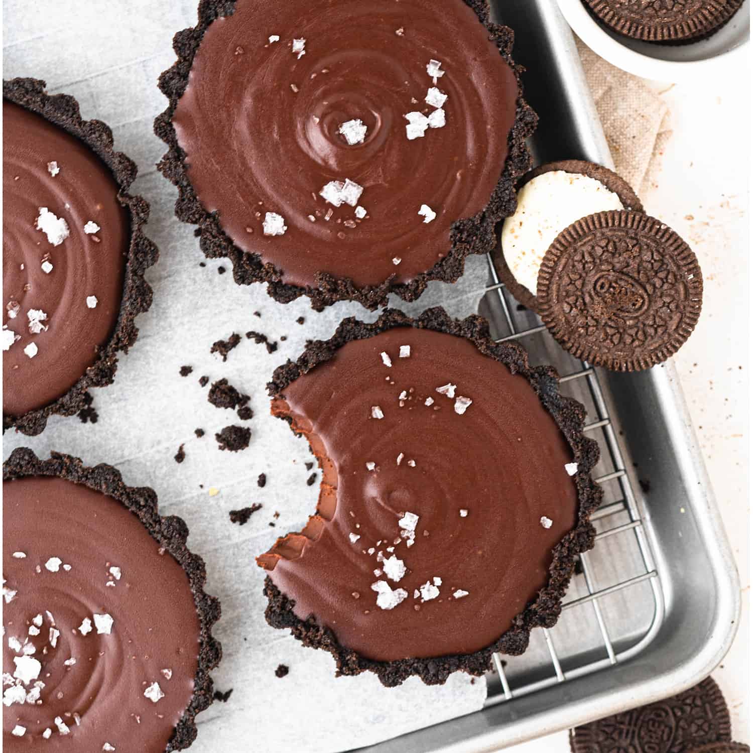 chocolate tartlets with a no-bake oreo crust sprinkled with flaky salt