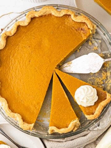 Pumpkin pie in a flaky crust topped with whipped cream