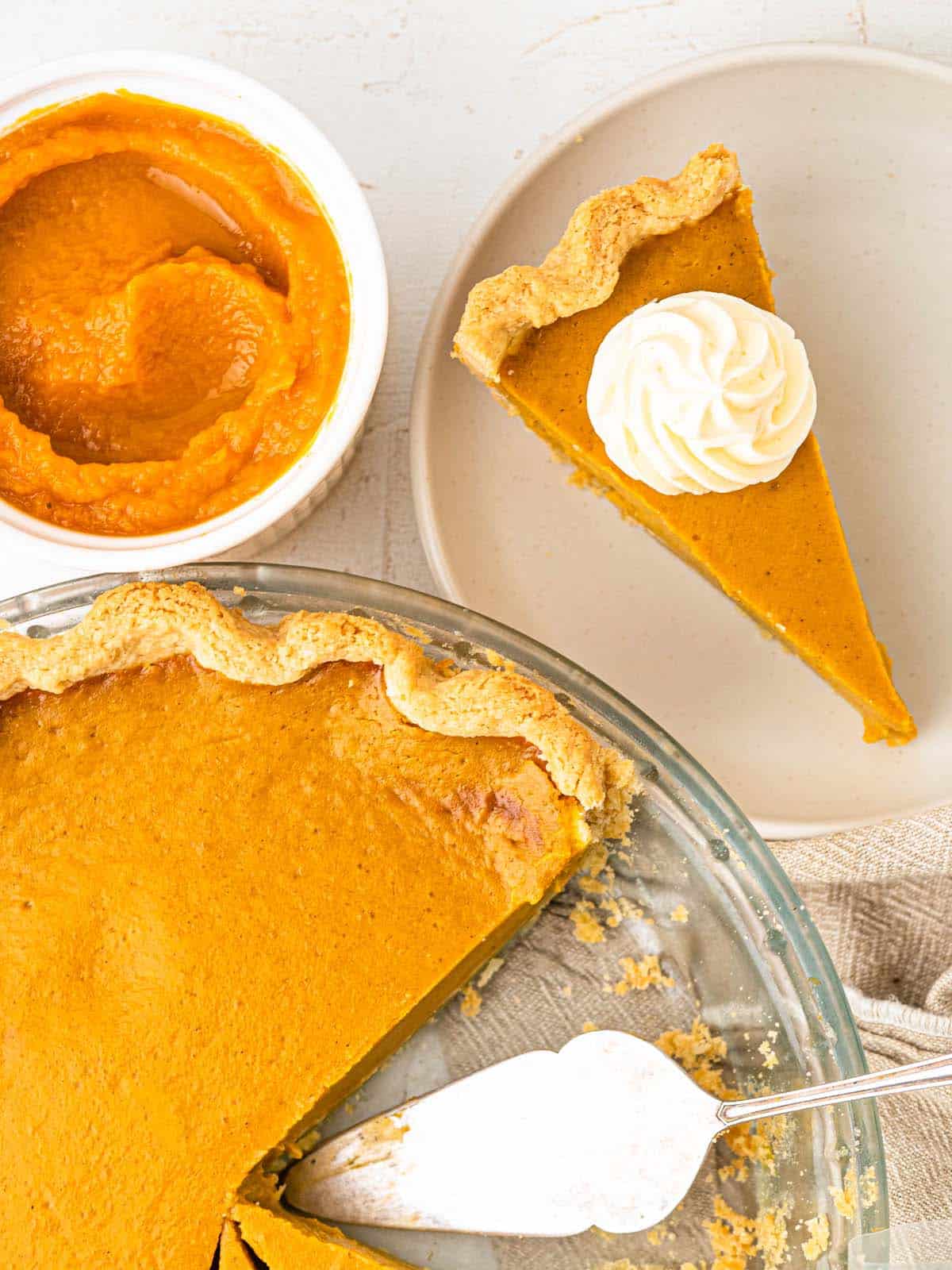 Pumpkin pie in a flaky crust topped with whipped cream