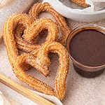 spanish vegan churros rolled in cinnamon sugar with chocolate sauce