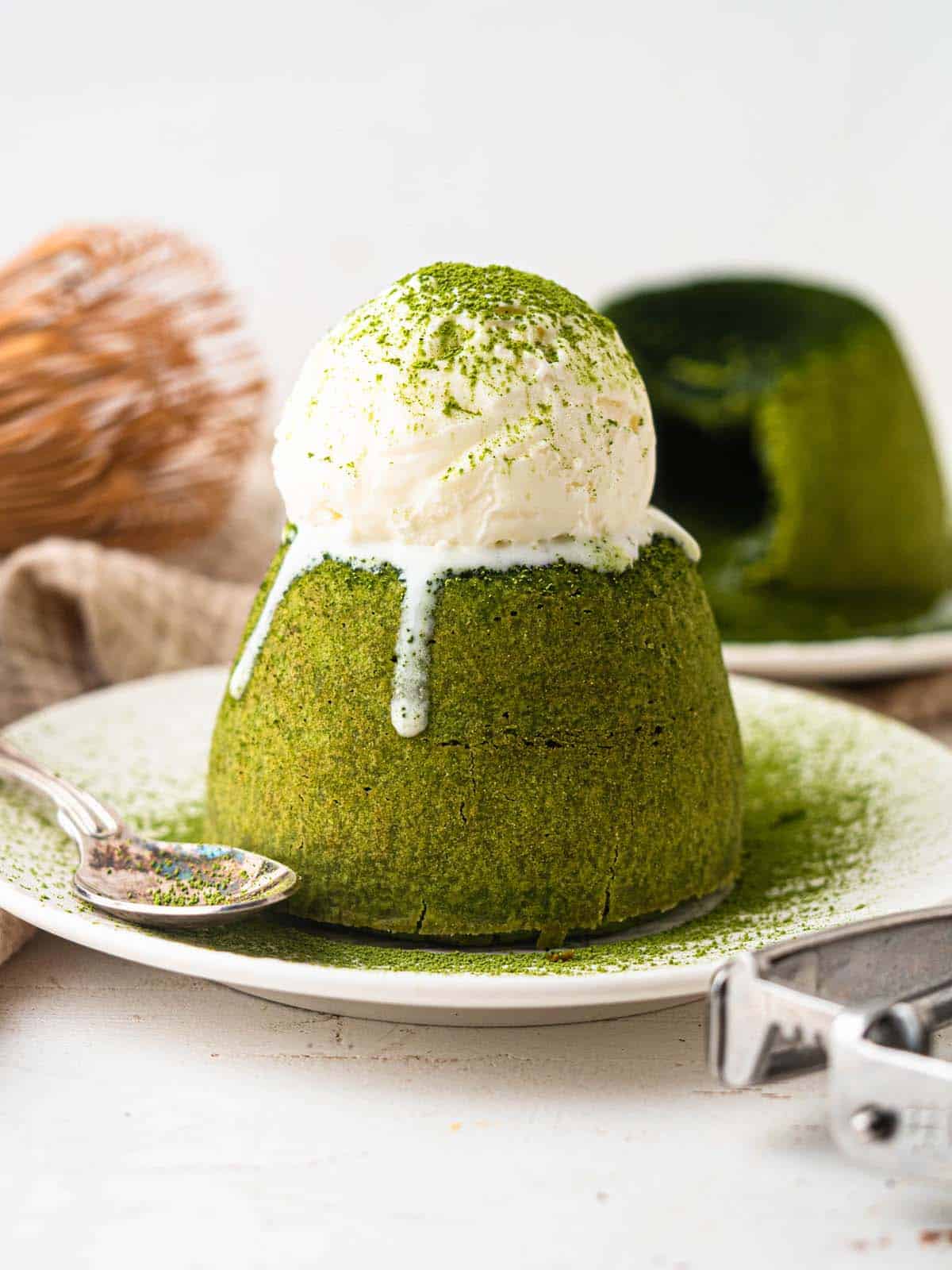 Matcha lava cake topped with vanilla ice cream and green tea powder