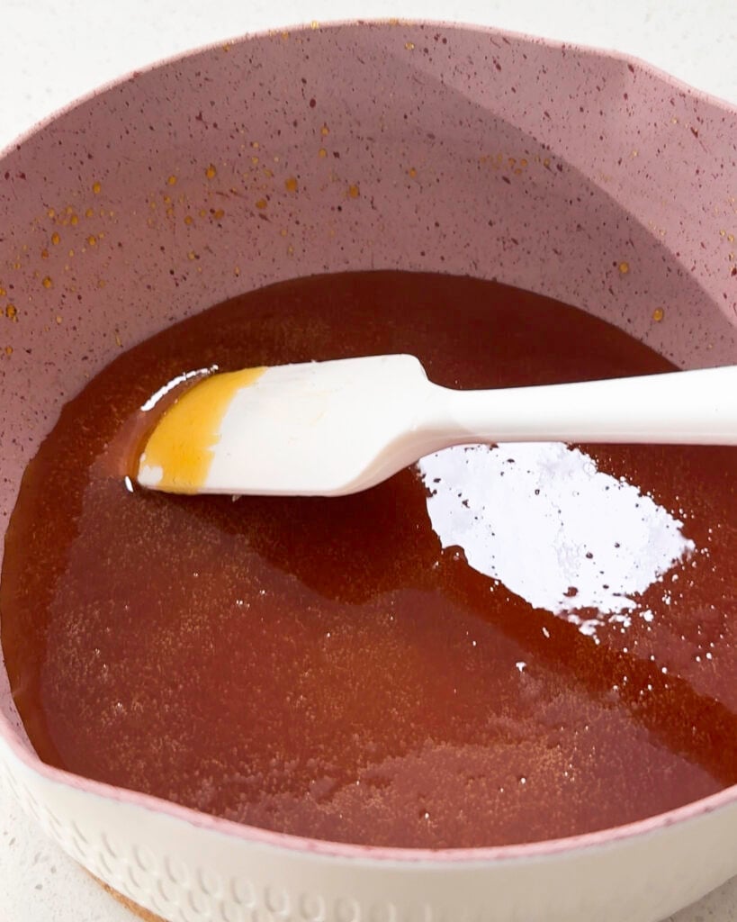 Amber caramel mixture being stirred in saucepan - Catherine Zhang Amber caramel mixture being stirred in saucepan