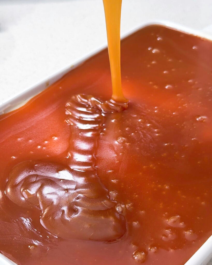 Caramel sauce is visibly being poured over the cream layer - Catherine Zhang Caramel sauce is visibly being poured over the cream layer