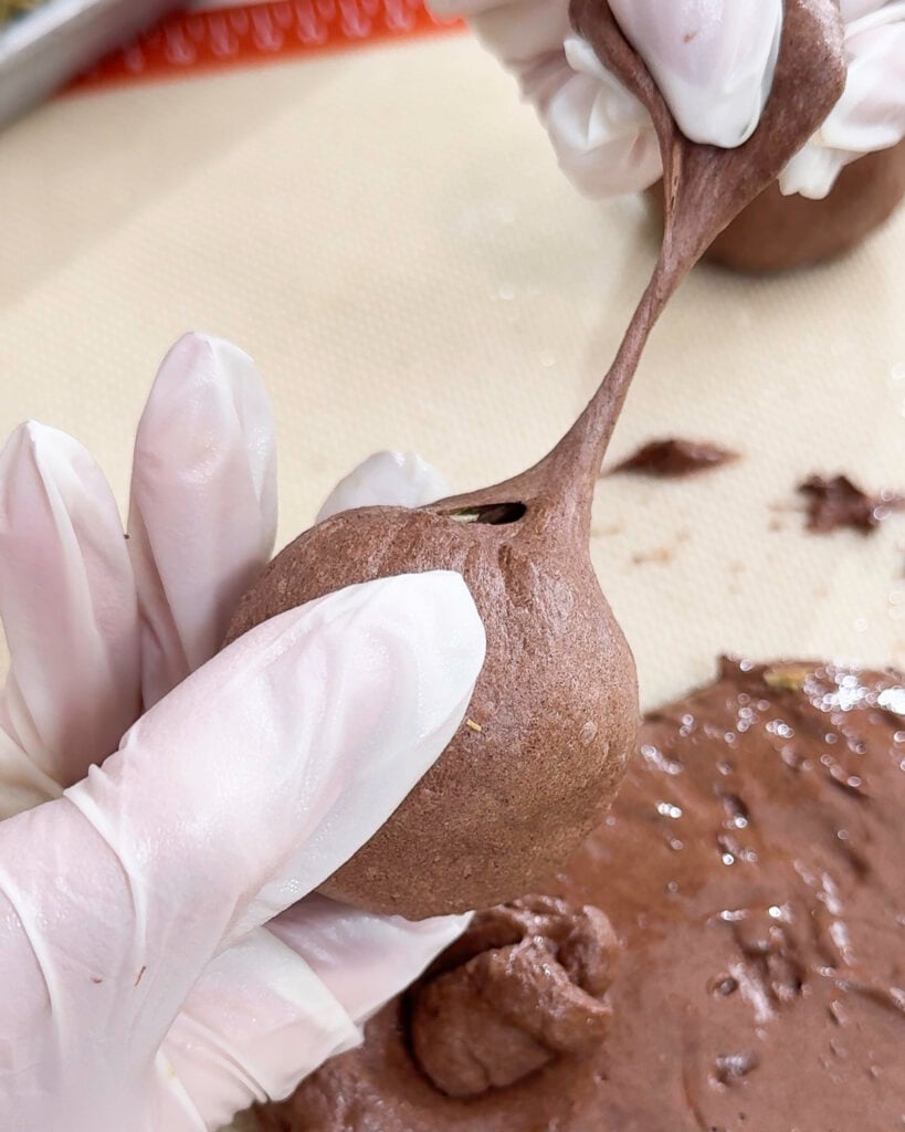 Placing pistachio filling ball inside chocolate marshmallow dough - Catherine Zhang Placing pistachio filling ball inside chocolate marshmallow dough