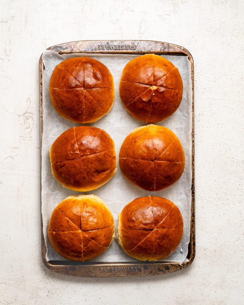 Cut round buns arranged on a tray for Korean cream cheese garlic bread preparation - Catherine Zhang Cut round buns arranged on a tray for Korean cream cheese garlic bread preparation