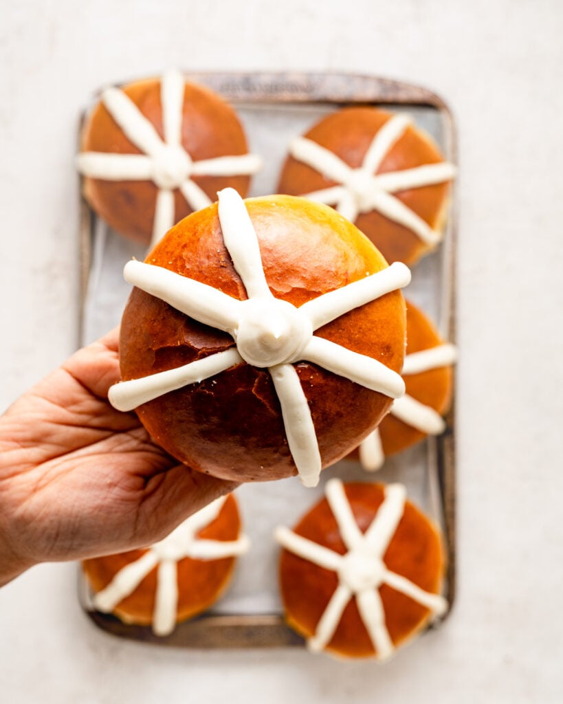 Hand holding a bun filled with white piped cream - Catherine Zhang Hand holding a bun filled with white piped cream