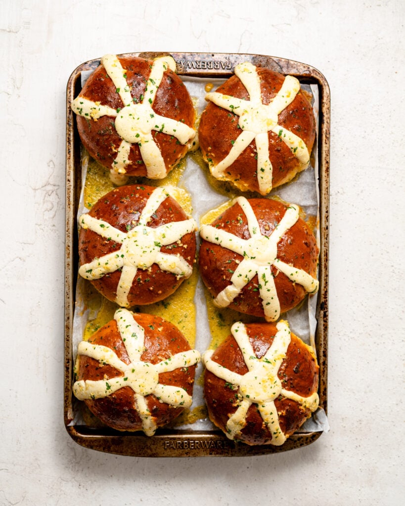 Korean cream cheese garlic bread buns with white filling and yellow herb coating on a baking tray - Catherine Zhang Korean cream cheese garlic bread buns with white filling and yellow herb coating on a baking tray