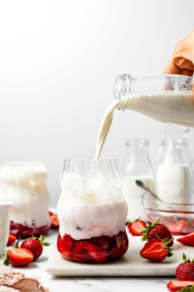 White liquid poured over ice and strawberry mixture - Catherine Zhang White liquid poured over ice and strawberry mixture