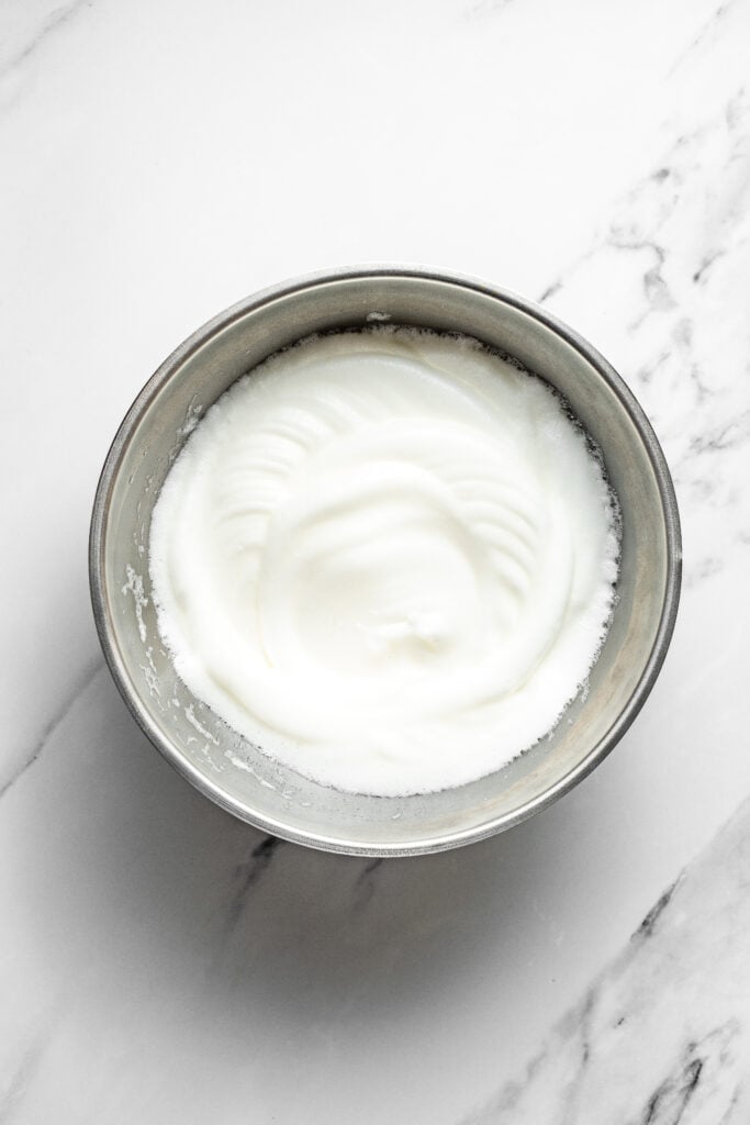 Foamy egg whites in a metal mixing bowl for pandan chiffon cake meringue - Catherine Zhang Foamy egg whites in a metal mixing bowl for pandan chiffon cake meringue