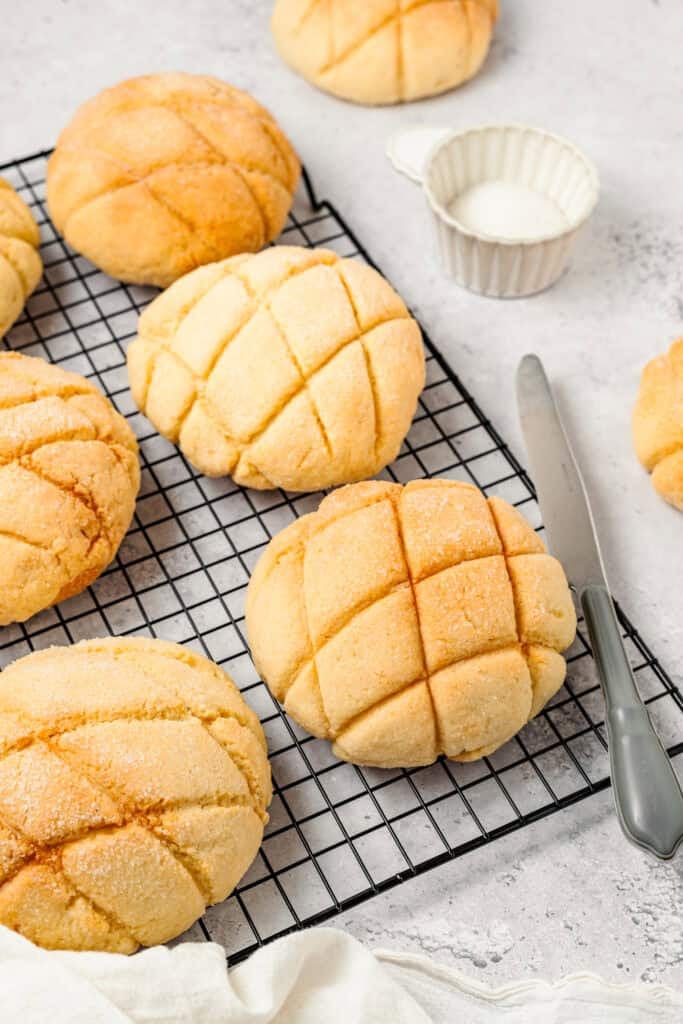 Golden baked Melon Pan buns cooling on a wire rack