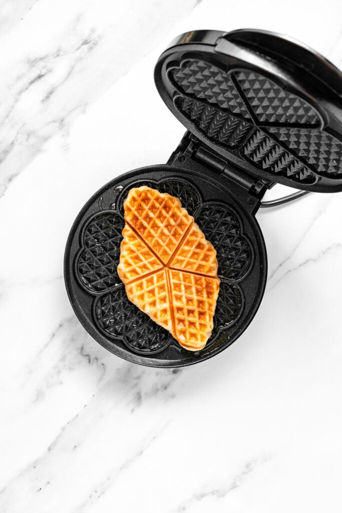 Golden browned croffle inside an open waffle iron - Catherine Zhang Golden browned croffle inside an open waffle iron