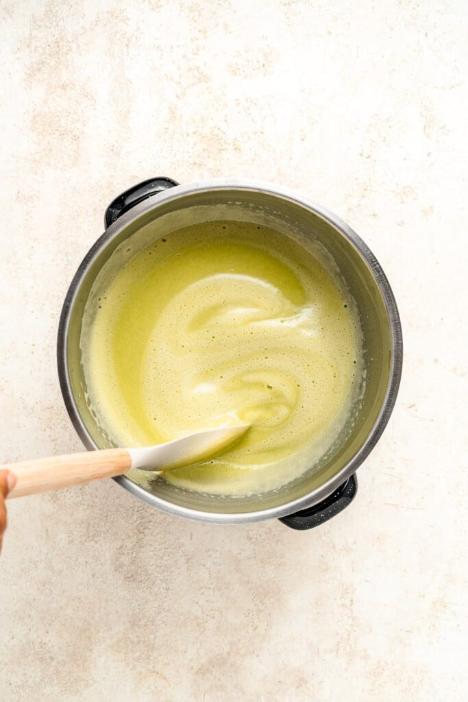 Pale green Pandan Kaya Jam mixture being stirred in a metal pot - Catherine Zhang Pale green Pandan Kaya Jam mixture being stirred in a metal pot