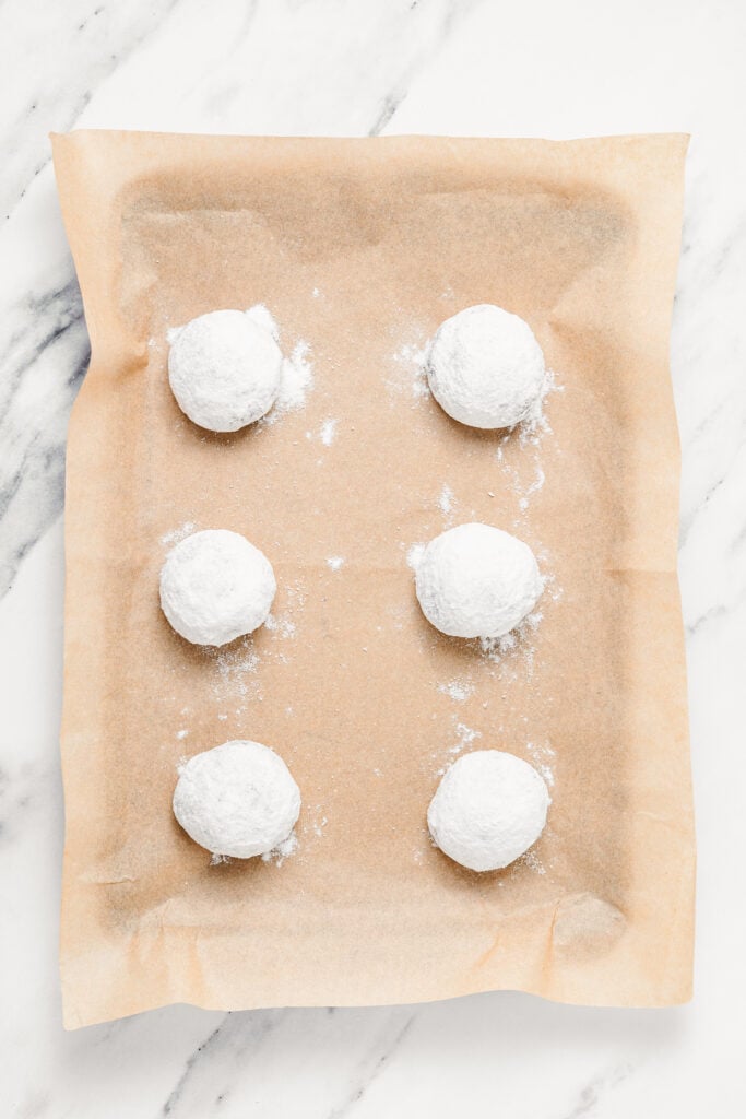 Powder coated dough balls arranged on parchment - Catherine Zhang Powder coated dough balls arranged on parchment