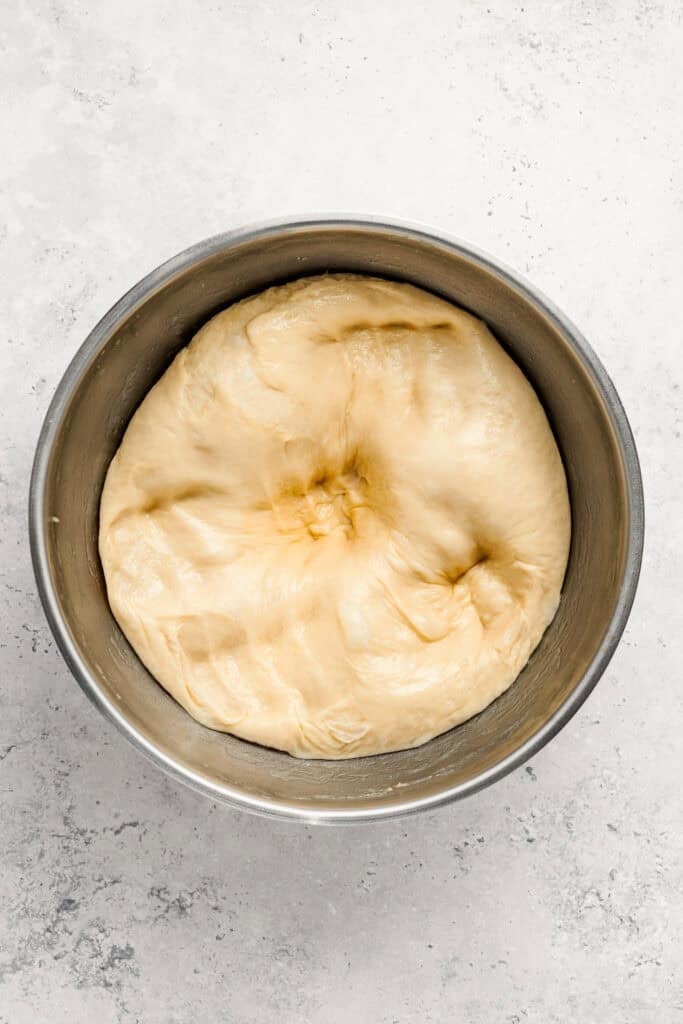 Proofed Melon Pan dough with visible finger indentations in a bowl