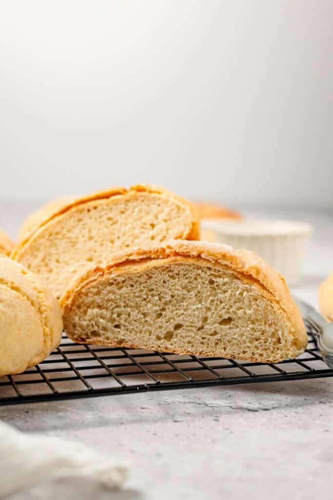 Sliced baked Melon Pan bun showing soft interior crumb on a cooling rack