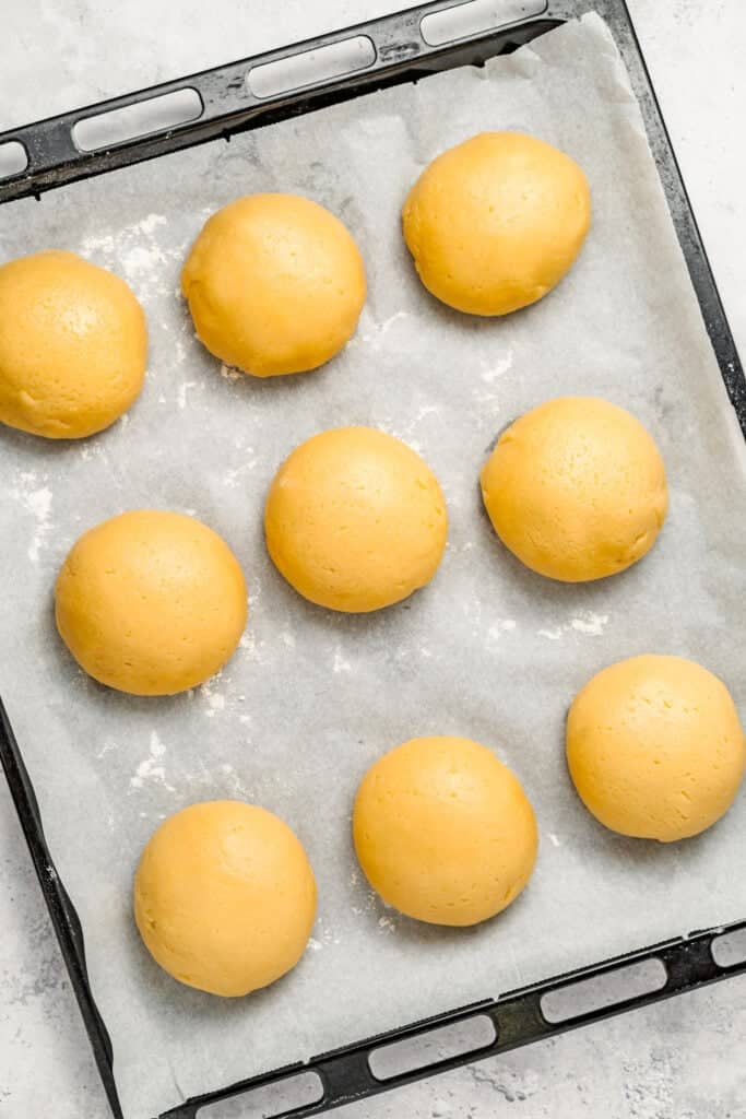 Smooth Melon Pan dough balls arranged on parchment before topping