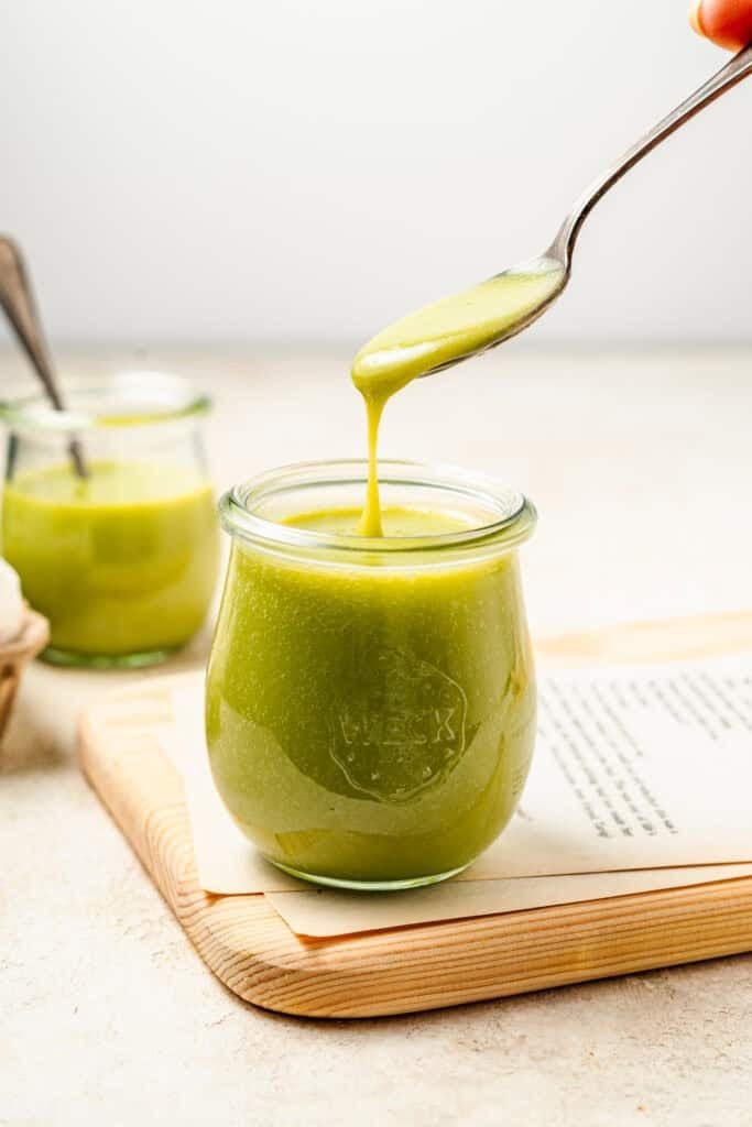 Thick smooth Pandan Kaya Jam dripping from a spoon into a glass jar - Catherine Zhang Thick smooth Pandan Kaya Jam dripping from a spoon into a glass jar