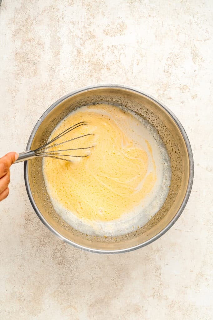Whisking pale yellow mixture with white swirls - Catherine Zhang Whisking pale yellow mixture with white swirls