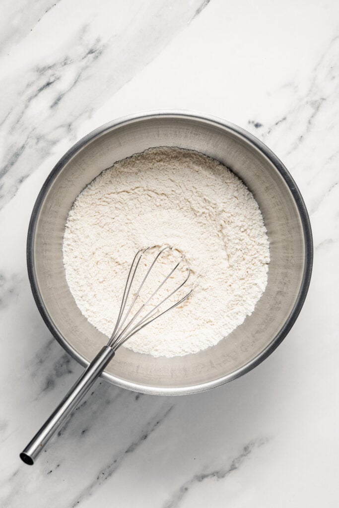 Whisking white dry ingredients in a metal bowl - Catherine Zhang Whisking white dry ingredients in a metal bowl
