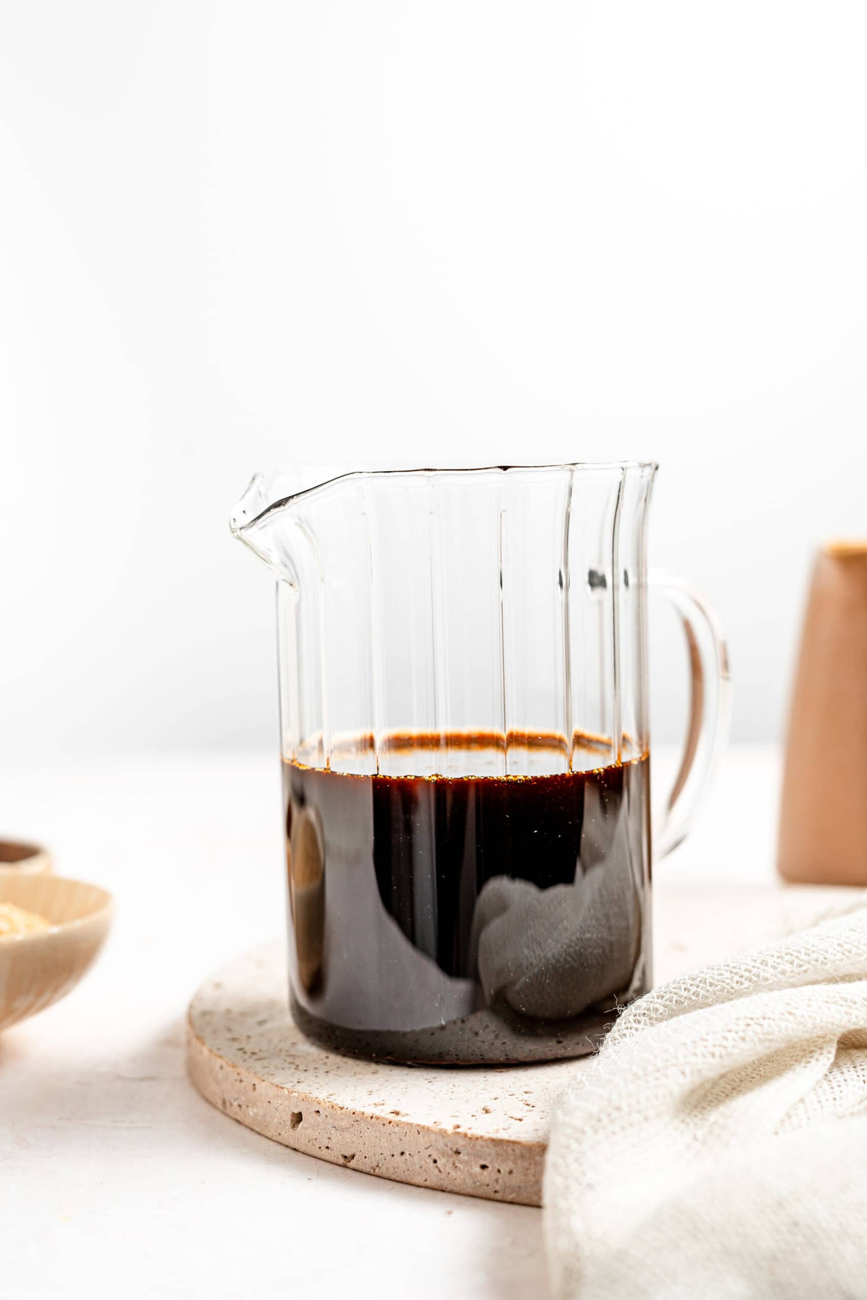 A glass beaker of homemade kuromitsu Japanese black sugar syrup - Catherine Zhang A glass beaker of homemade kuromitsu Japanese black sugar syrup