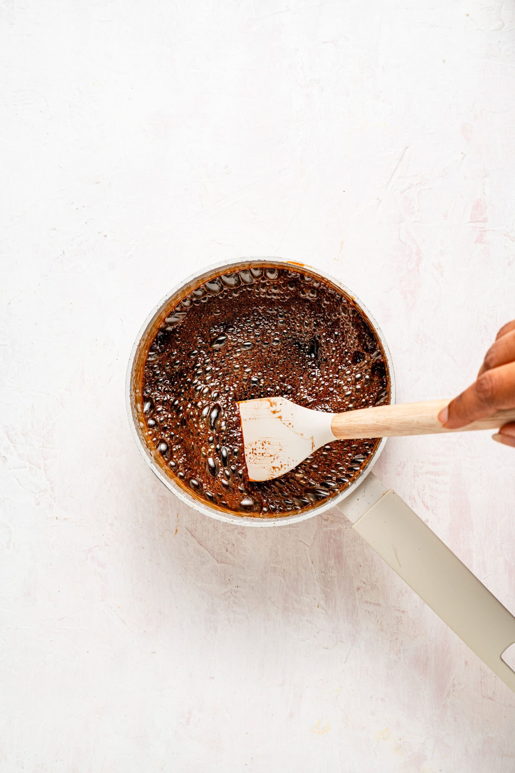 Stirring the dissolving black sugar syrup with a spatula - Catherine Zhang Stirring the dissolving black sugar syrup with a spatula
