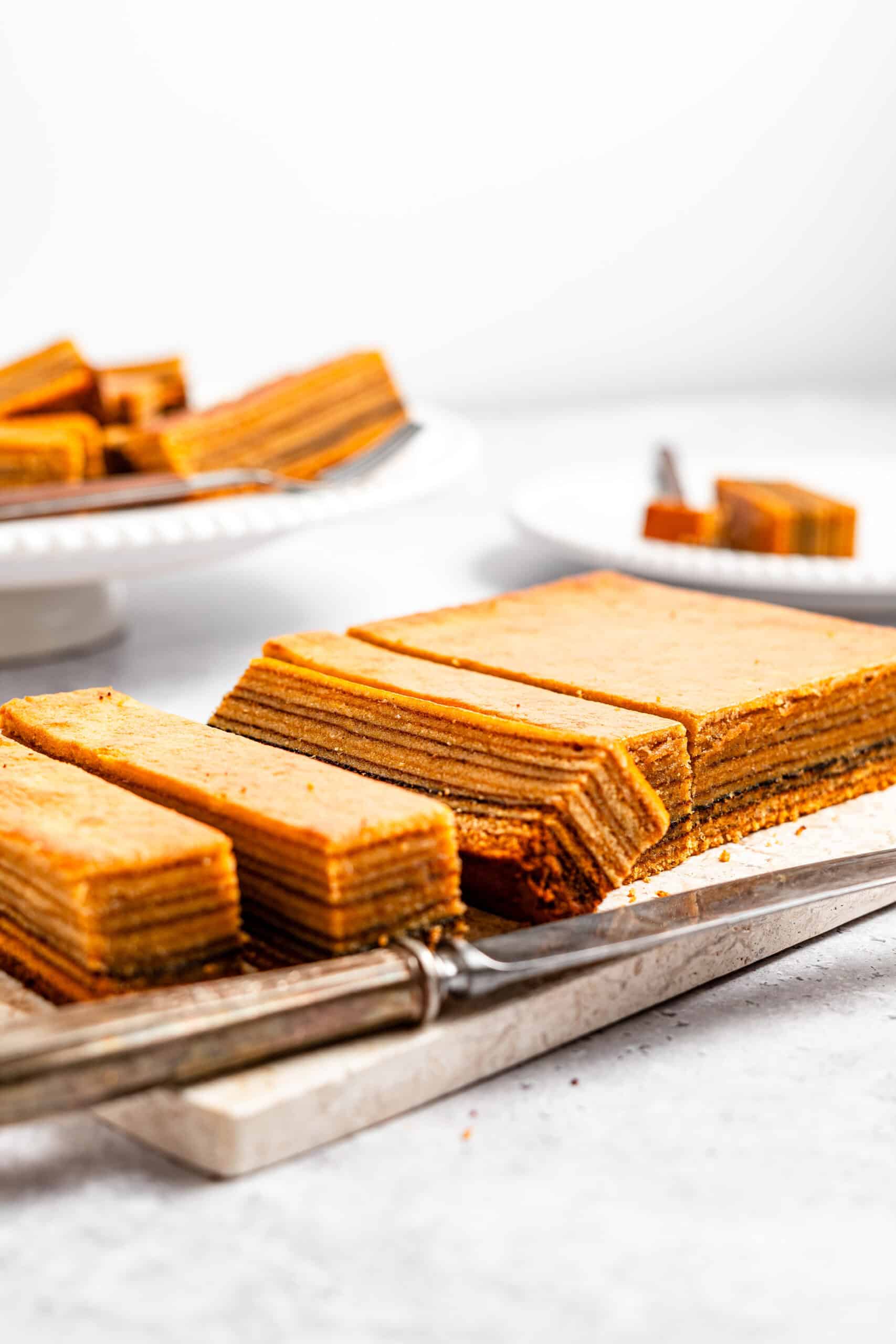 A lapis legit loaf sliced on a wooden board - Catherine Zhang A lapis legit loaf sliced on a wooden board