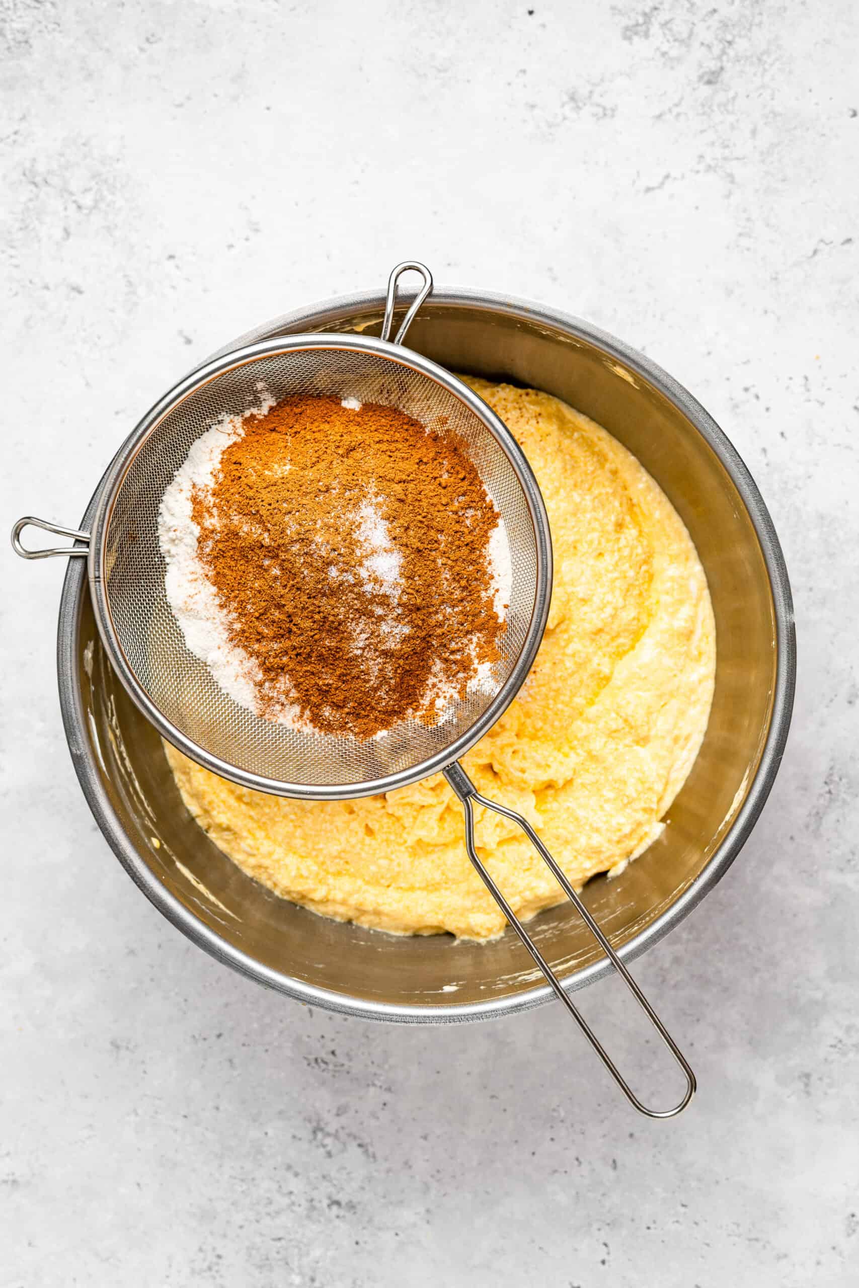 Sifting cake flour, milk powder and spices over the batter - Catherine Zhang Sifting cake flour, milk powder and spices over the batter