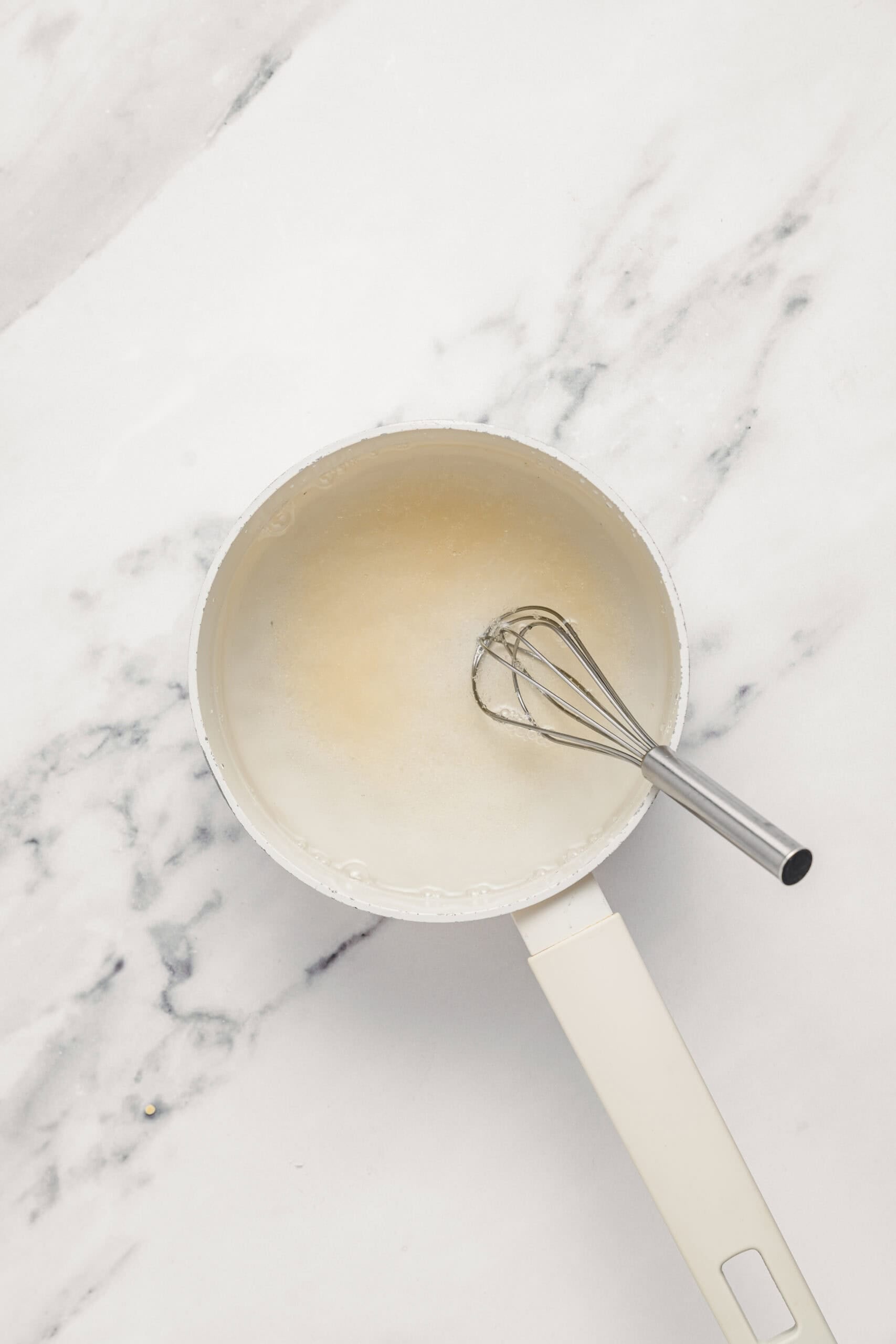 Agar agar powder whisked into water in a saucepan for pandan jelly - Catherine Zhang Agar agar powder whisked into water in a saucepan and left to hydrate