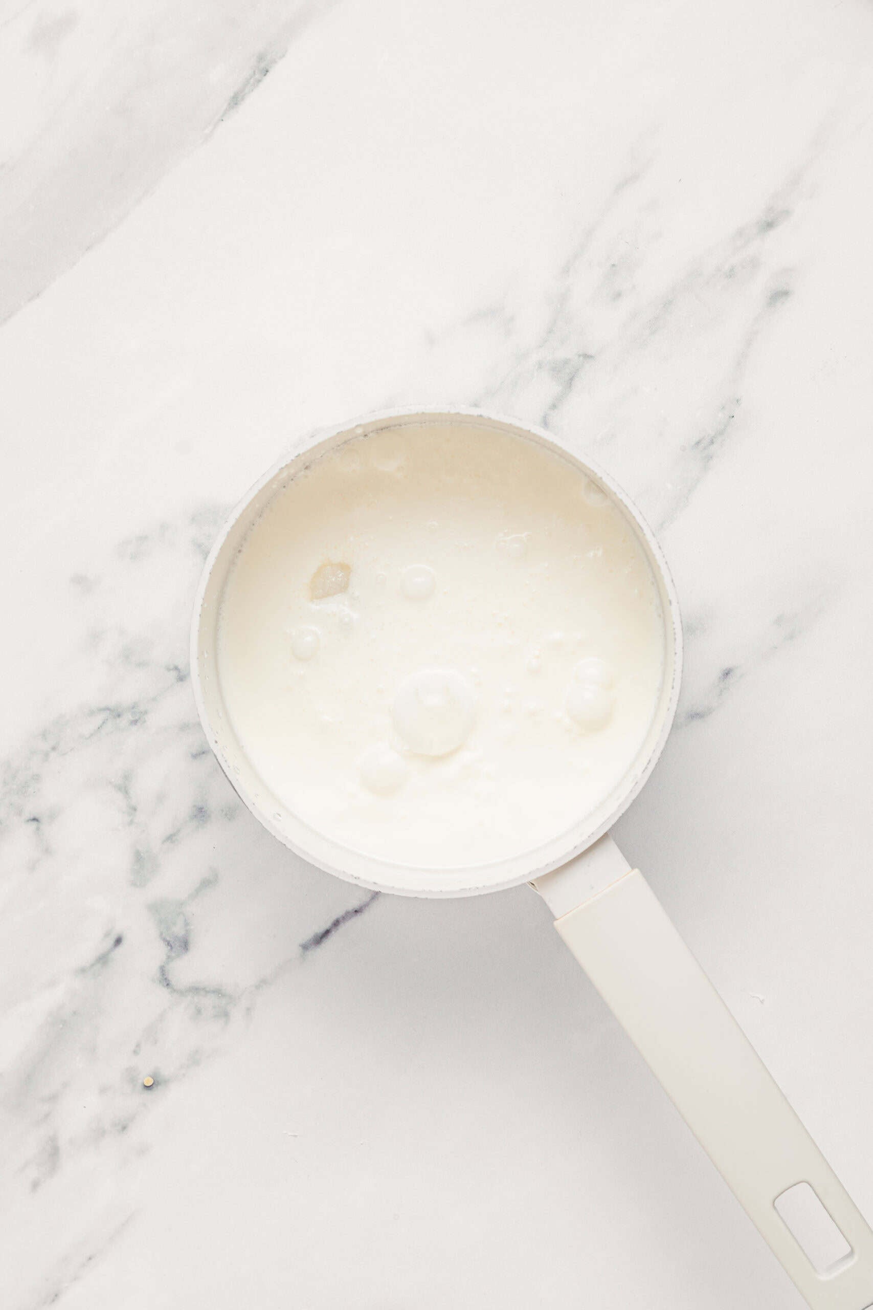 Coconut milk, sugar and salt in a saucepan for the che ba mau coconut sauce - Catherine Zhang Coconut milk, sugar and salt whisked together in a saucepan for the coconut sauce