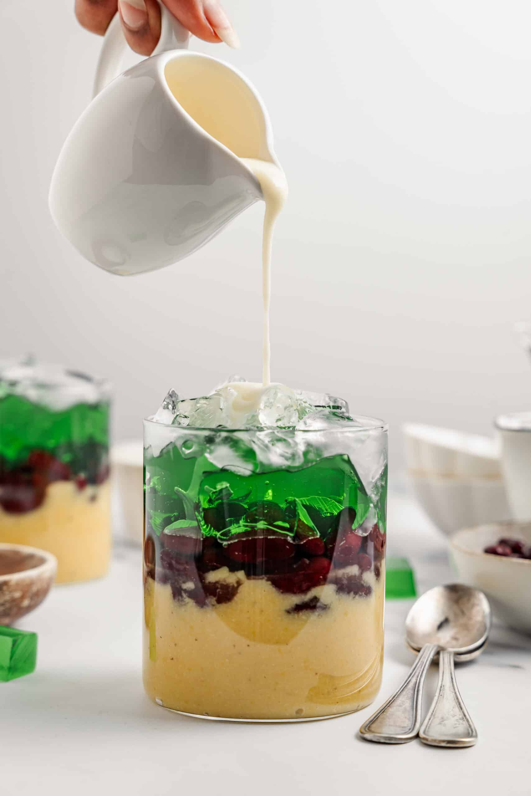 Coconut sauce pouring in a stream over the crushed ice of a che ba mau - Catherine Zhang Coconut sauce pouring in a thick stream over the crushed ice of a che ba mau