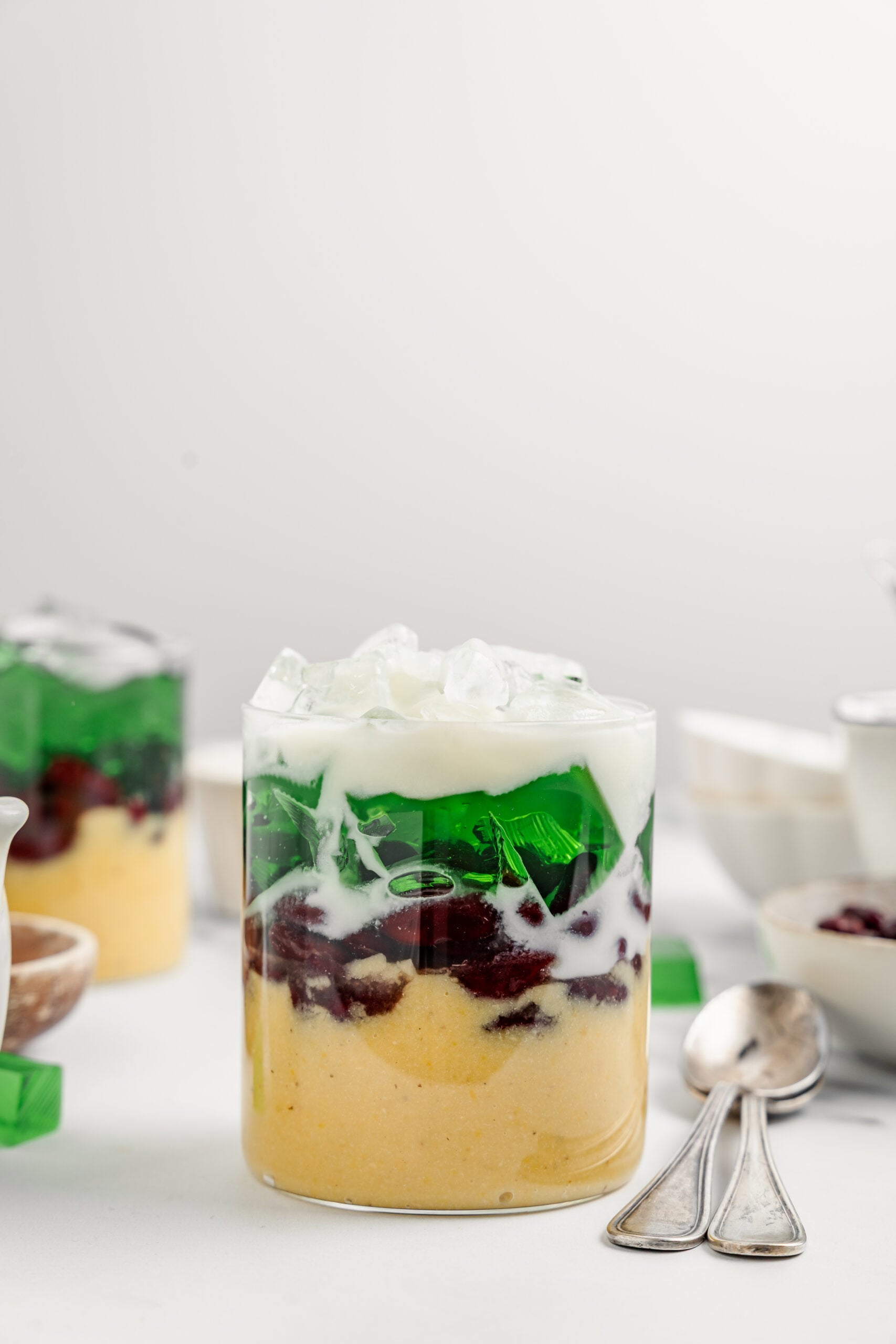 Finished che ba mau the Vietnamese three color dessert with coconut sauce poured over crushed ice - Catherine Zhang Finished che ba mau, the Vietnamese three color dessert, with coconut sauce poured over crushed ice and ready to stir