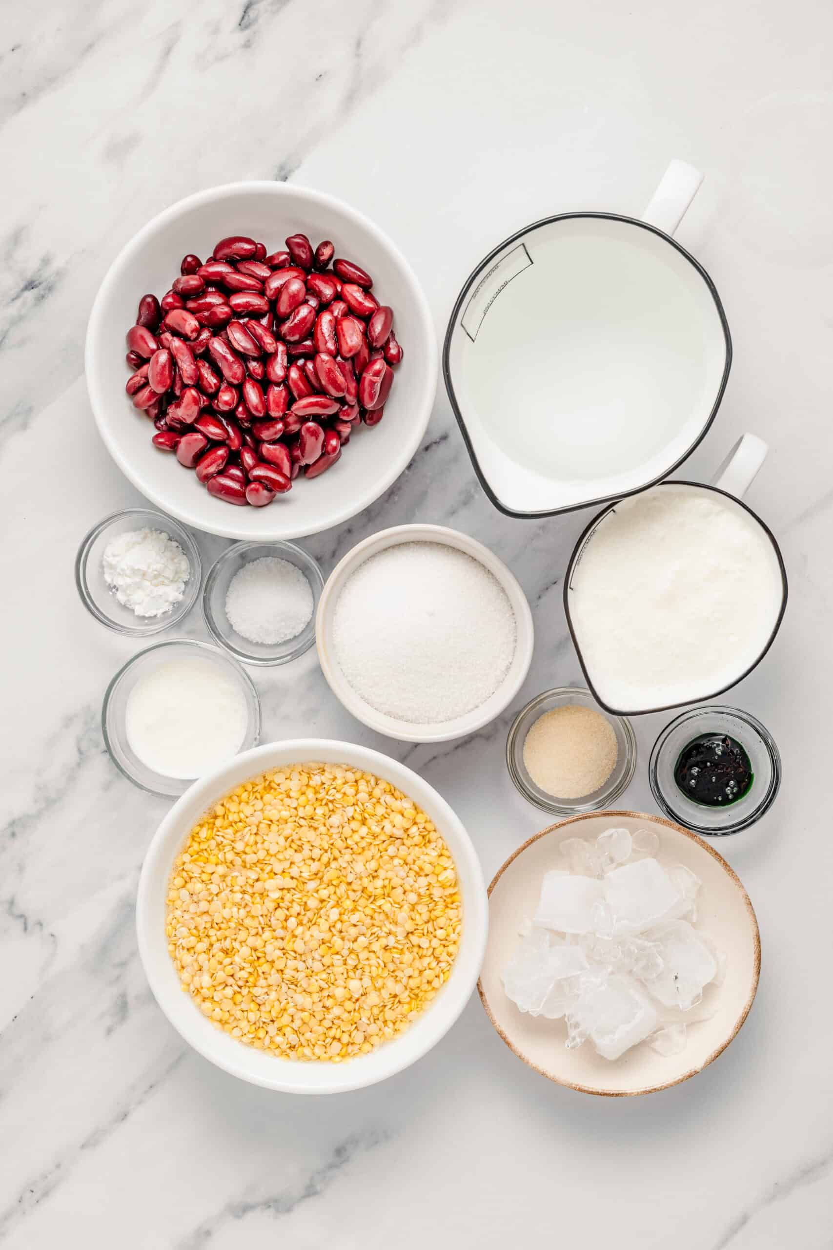 Che Ba Mau ingredients laid out: red beans, split mung beans, coconut milk, sugar, salt, p - Catherine Zhang Che ba mau ingredients laid out: red beans, split mung beans, coconut milk, sugar, salt, pandan extract, agar agar and crushed ice