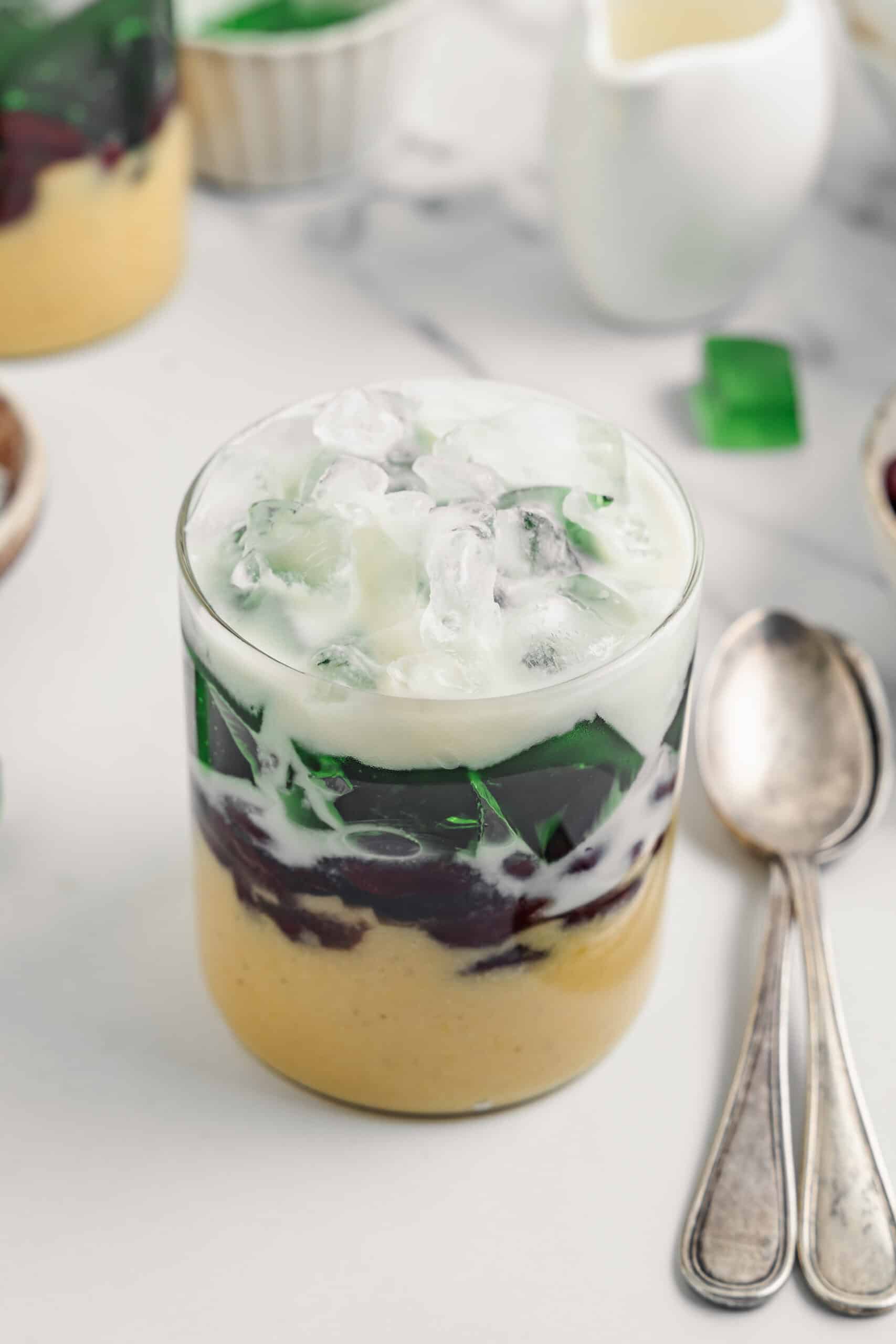 A tall glass of che ba mau with crushed ice and coconut sauce running down the layers - Catherine Zhang A tall glass of che ba mau with crushed ice and coconut sauce running down through the three layers