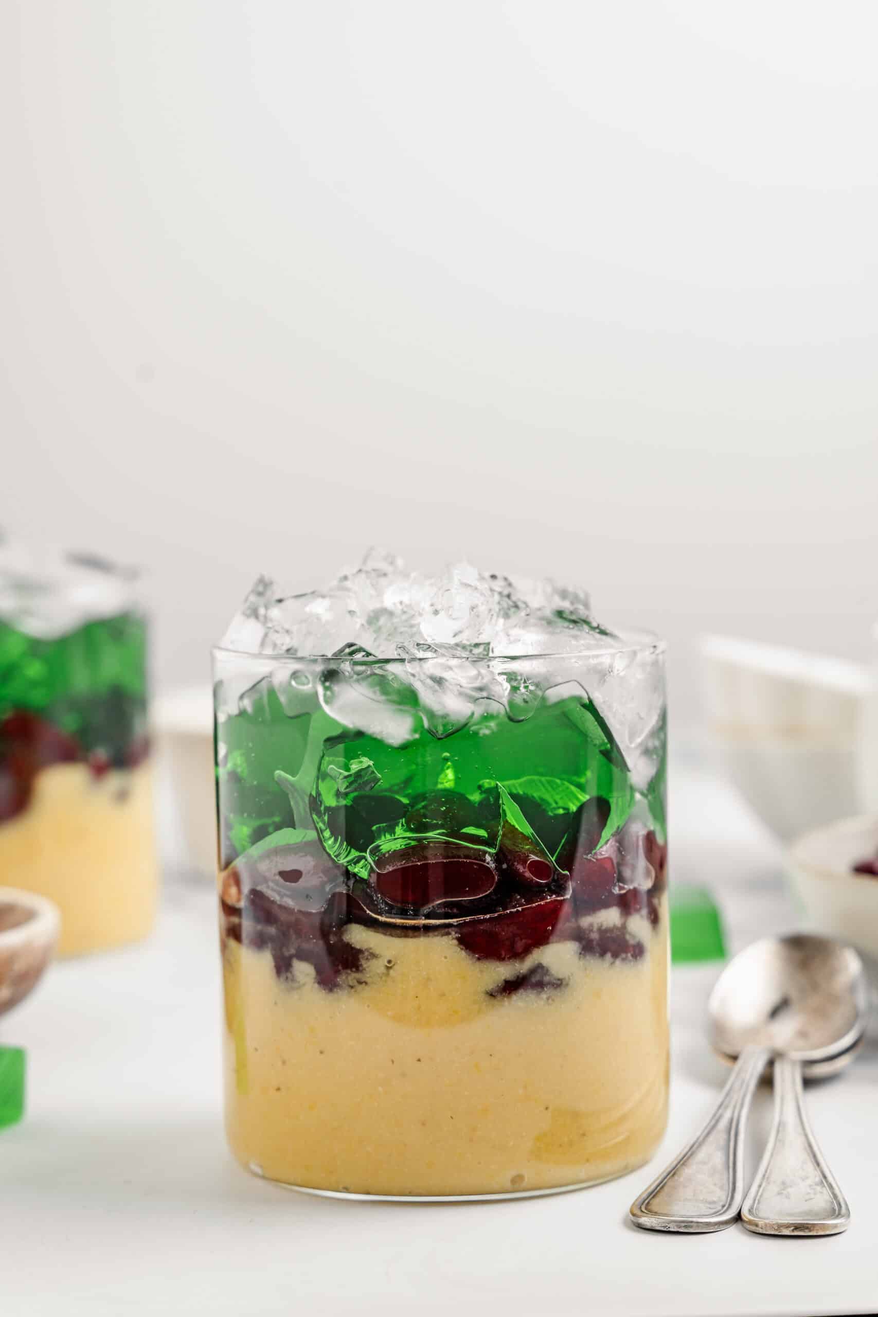 Pandan jelly strips and a mound of crushed ice added on top of the che ba mau layers - Catherine Zhang Pandan jelly strips and a mound of crushed ice added on top of the che ba mau layers