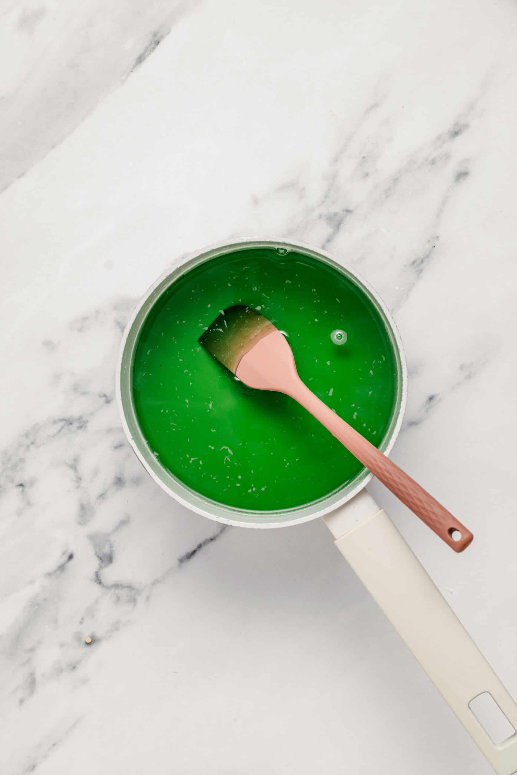 Bright green pandan agar jelly boiling in a saucepan before setting - Catherine Zhang Bright green pandan agar jelly boiling in a saucepan before it is poured out to set