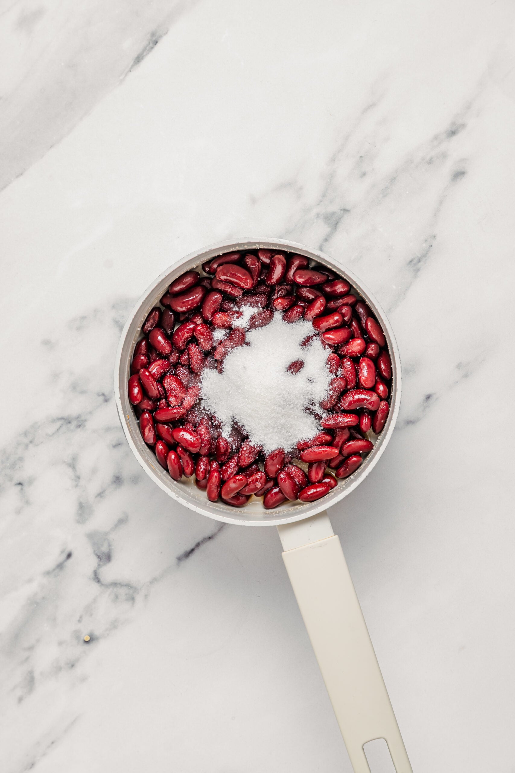 Cooked adzuki red beans in a saucepan with sugar added for che ba mau - Catherine Zhang Cooked adzuki red beans in a saucepan with sugar added for the che ba mau red bean layer