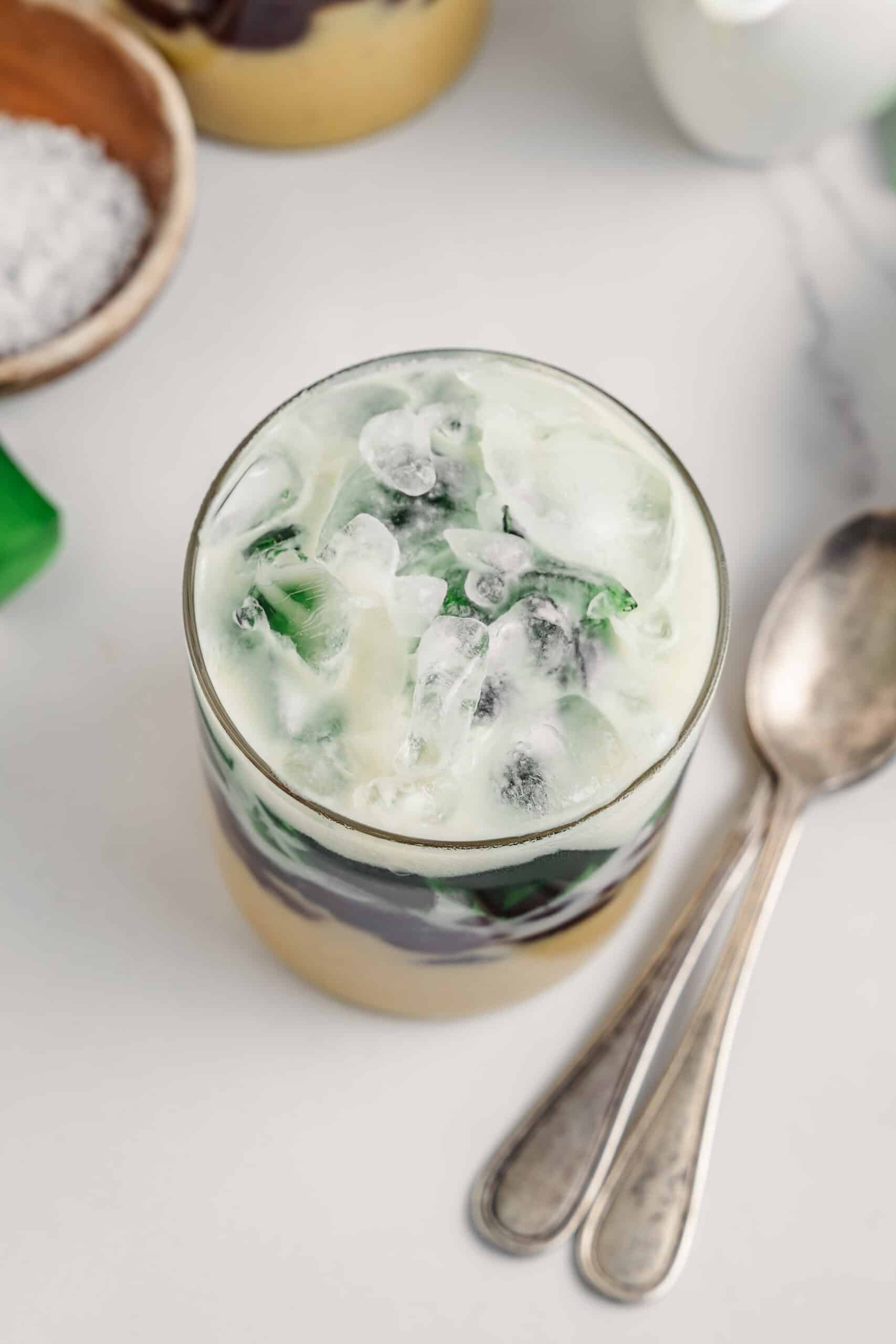 Top down view of a glass of che ba mau piled with crushed ice and coconut sauce - Catherine Zhang Top down view of a glass of che ba mau piled with crushed ice and coconut sauce