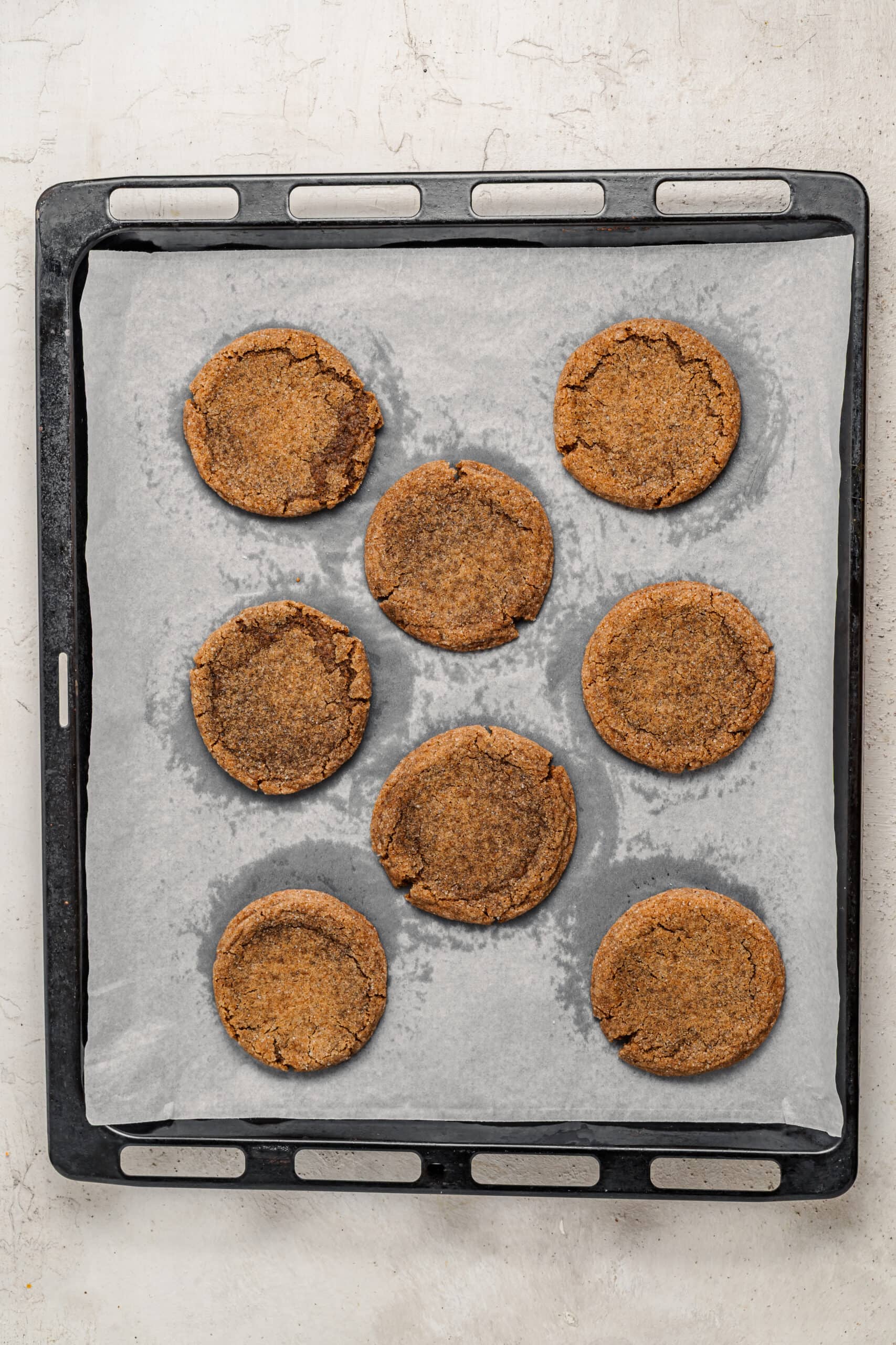 Baked gingerbread latte cookies with crackled tops on a tray - Catherine Zhang Baked gingerbread latte cookies with crackled tops on a tray