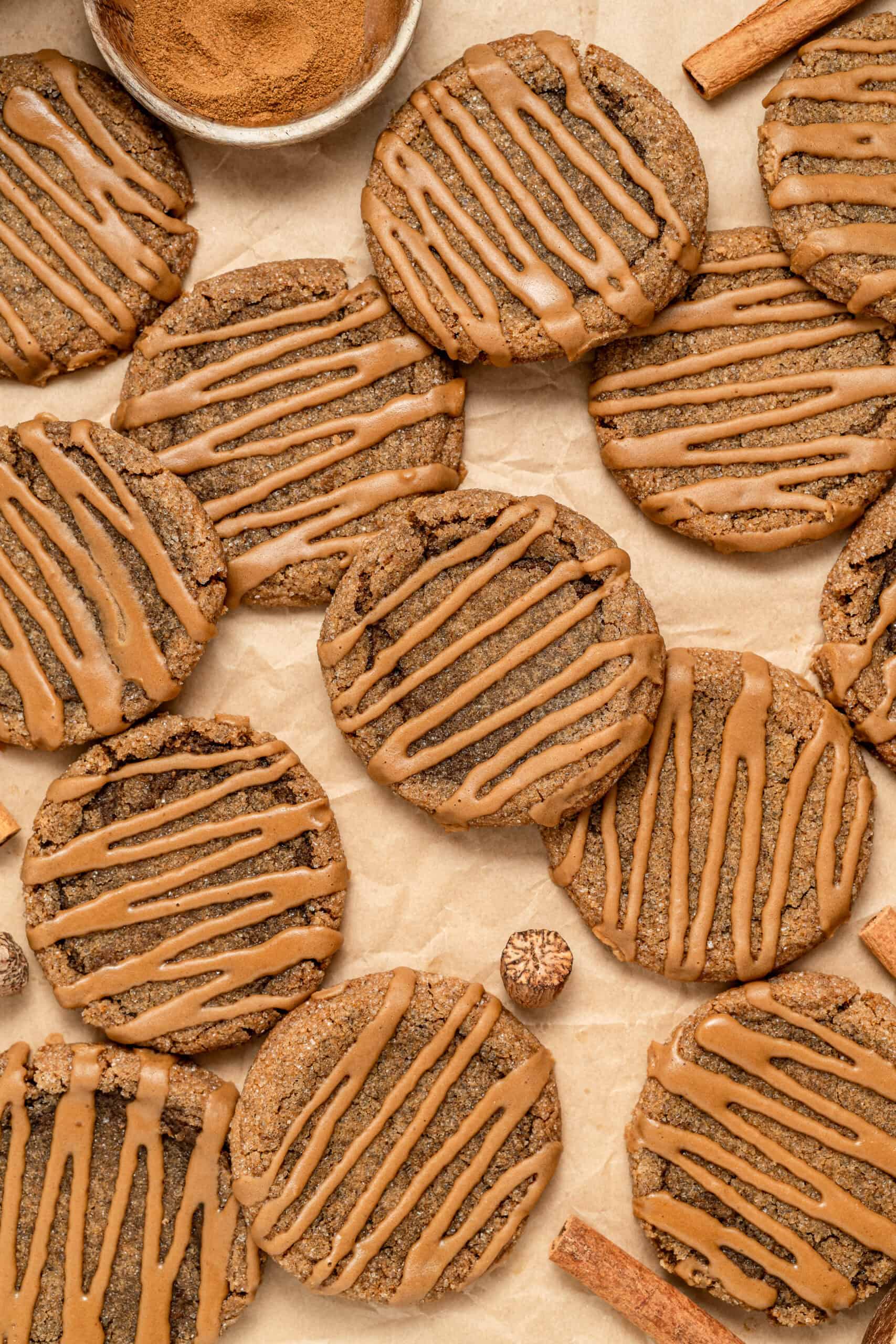 Gingerbread latte cookies scattered on parchment with glaze - Catherine Zhang Gingerbread latte cookies scattered on parchment with glaze