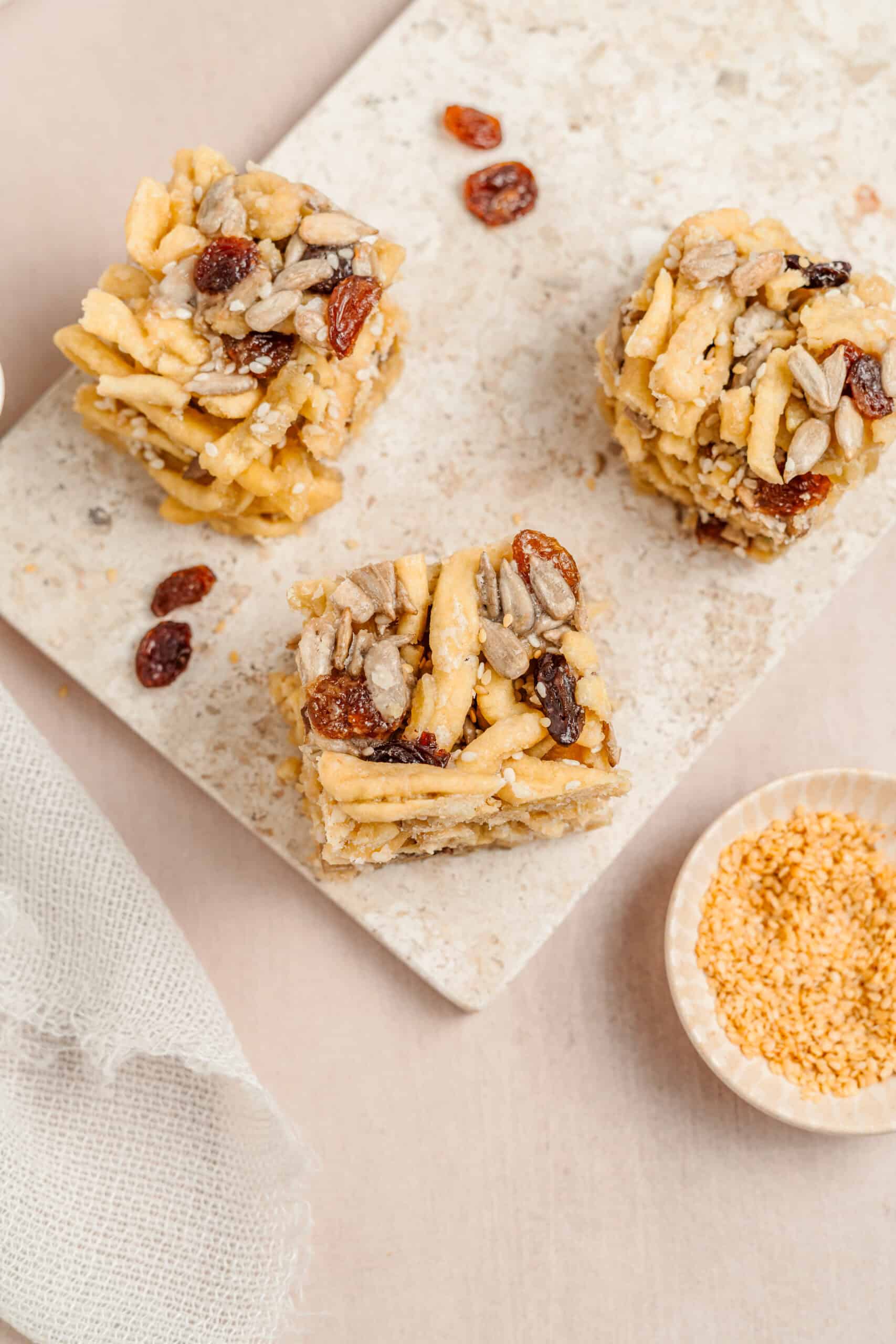Sachima Bars With Sesame - Catherine Zhang Sachima bars on a board beside a small bowl of sesame seeds