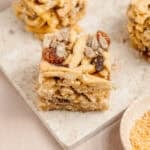 Sachima Chinese fried egg noodle candy bars on a board studded with raisins and sesame