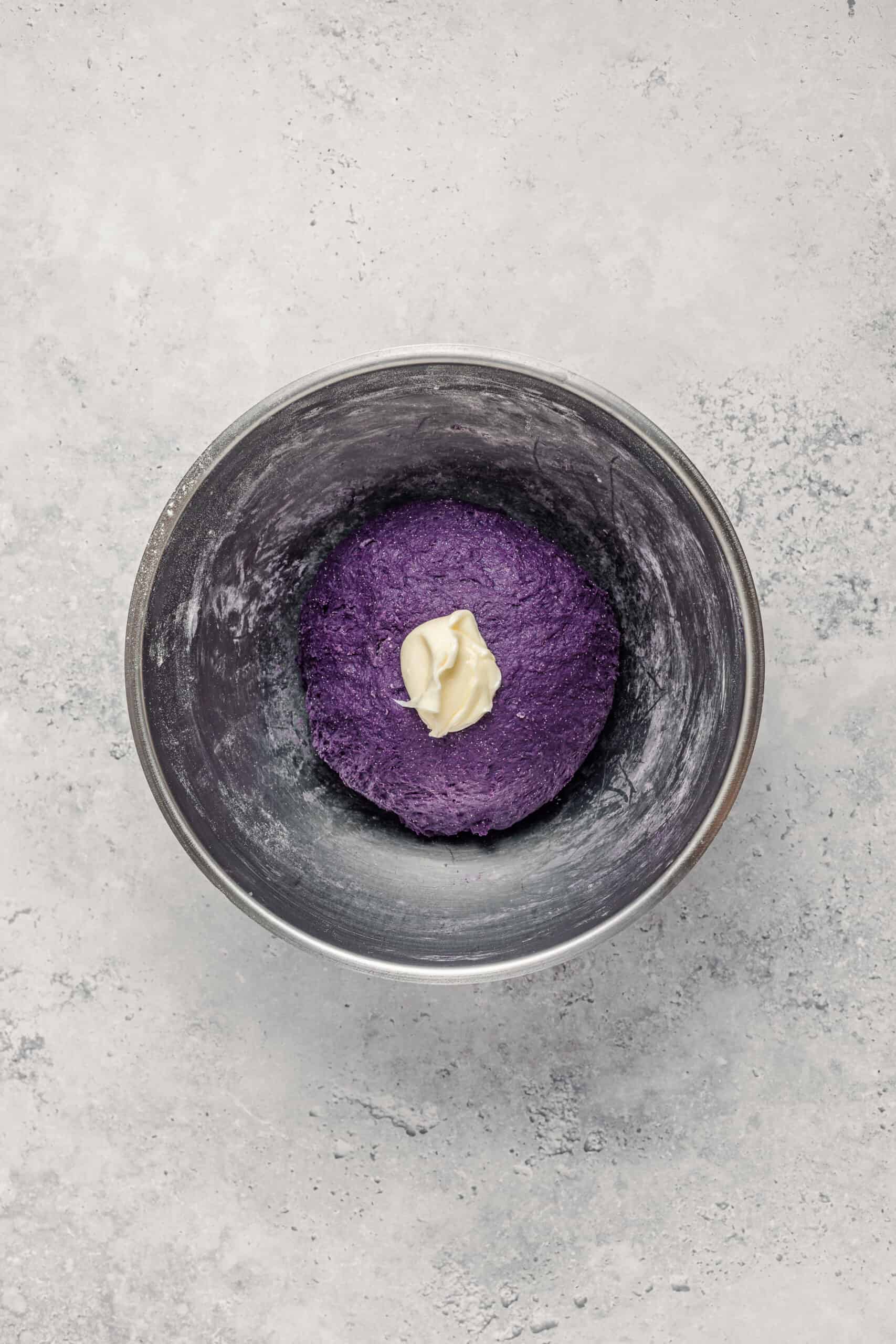 Adding Butter To Ube Dough - Catherine Zhang Adding a cube of softened butter to purple ube pandesal dough during kneading
