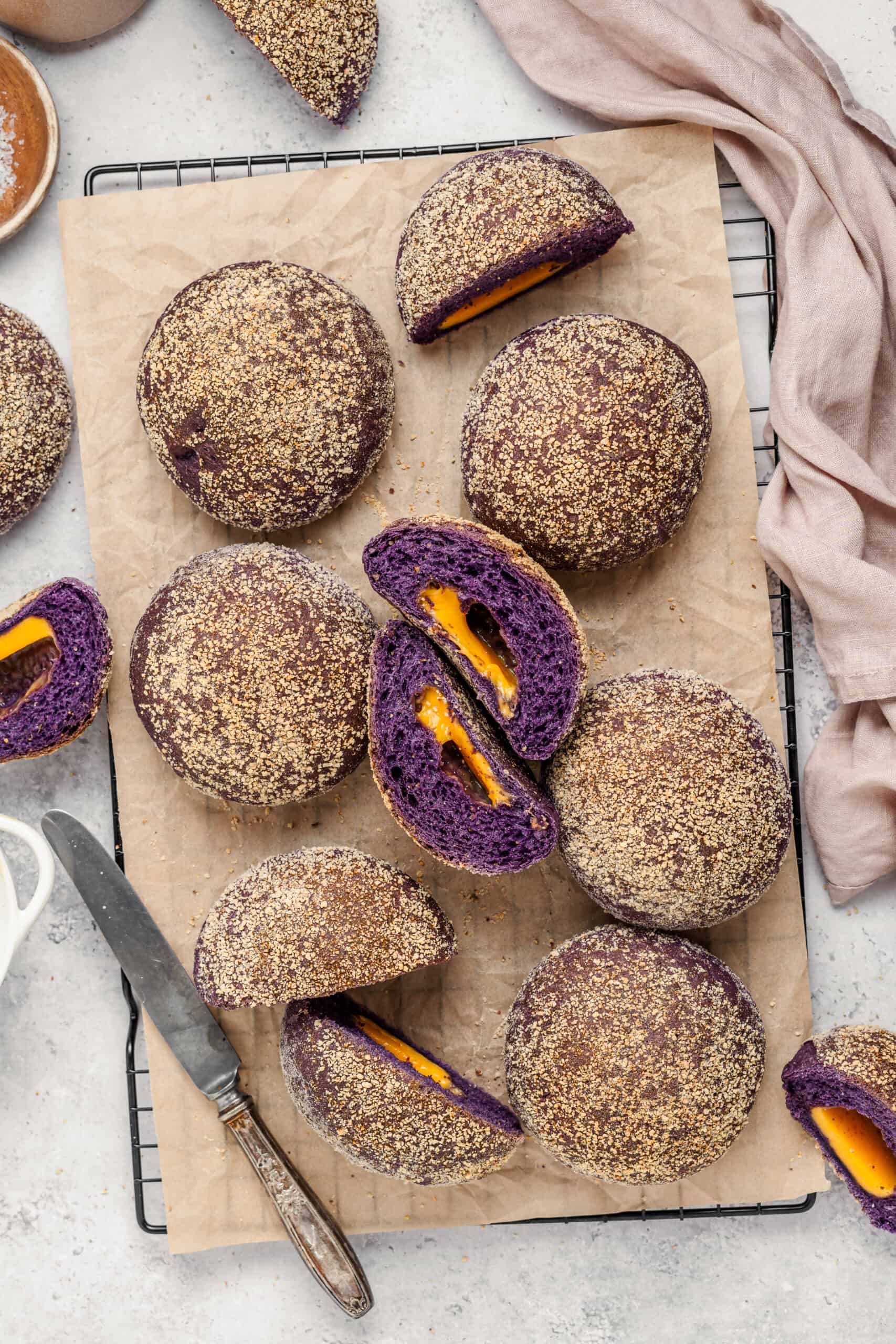 Ube Cheese Pandesal Styled - Catherine Zhang Ube cheese pandesal rolls styled on parchment with a soft pink linen