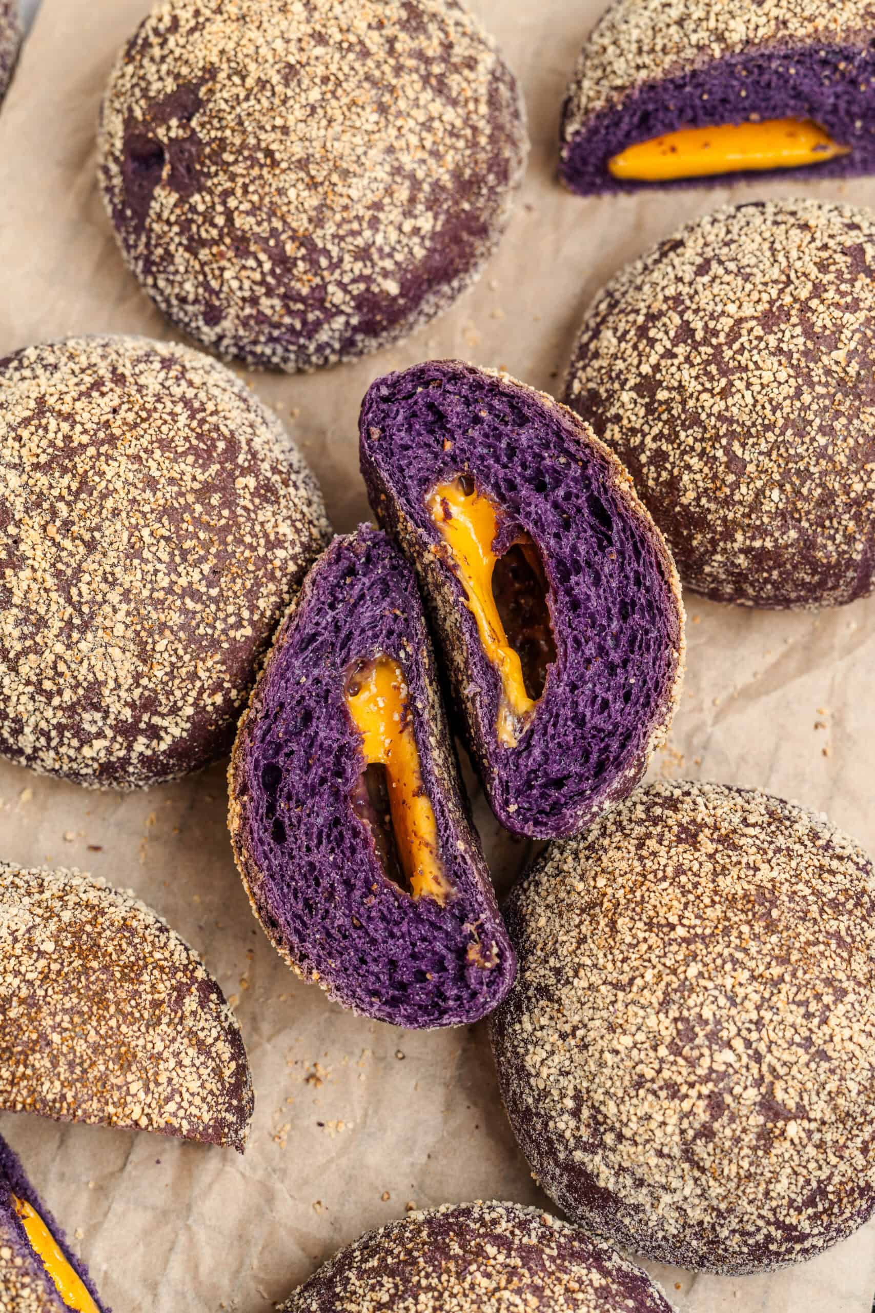 Ube Cheese Pandesal Cheese Pull - Catherine Zhang Ube cheese pandesal split open showing the melted cheese and vivid purple crumb