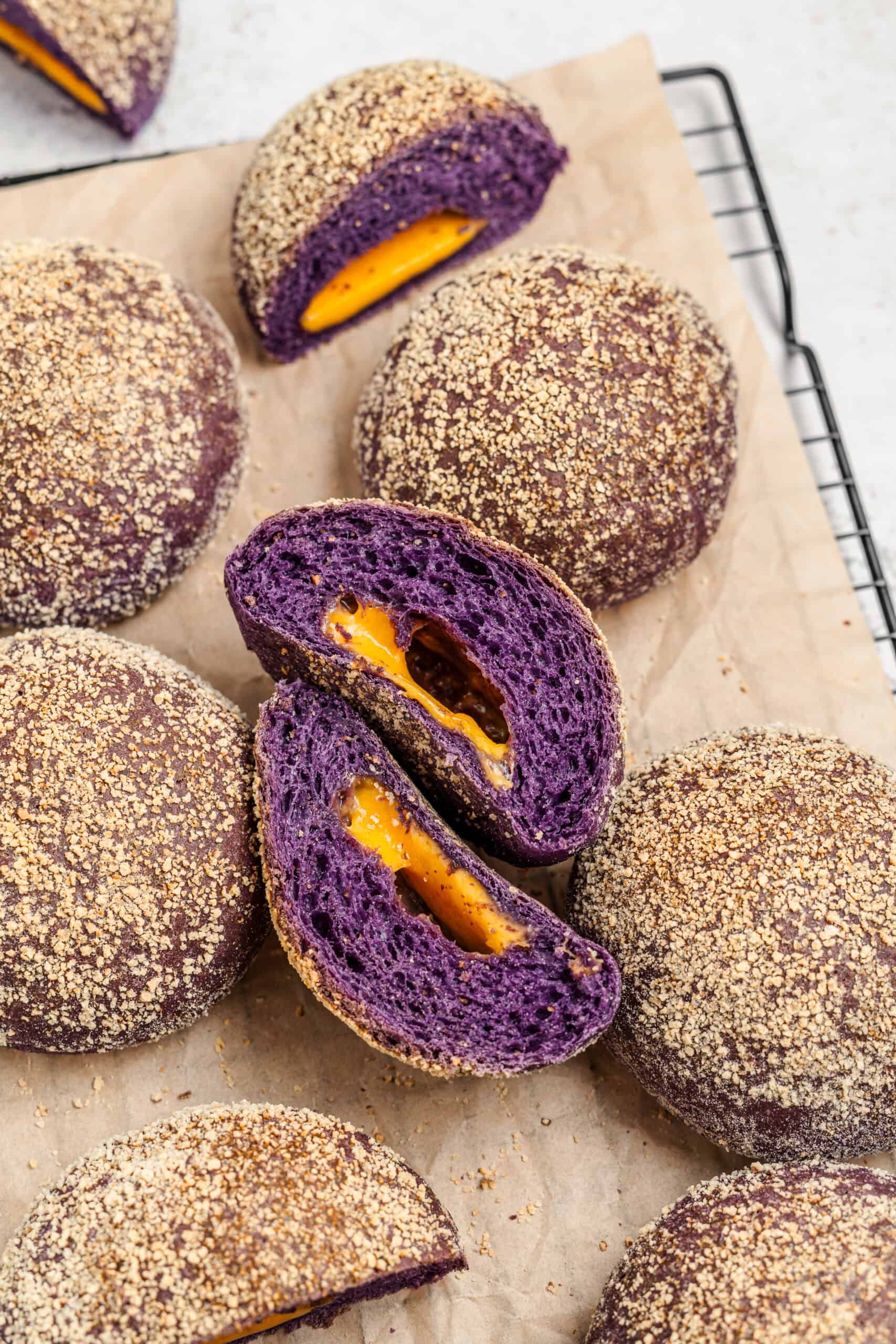 Halved Ube Cheese Pandesal - Catherine Zhang Halved ube cheese pandesal roll showing bright cheese filling and purple interior